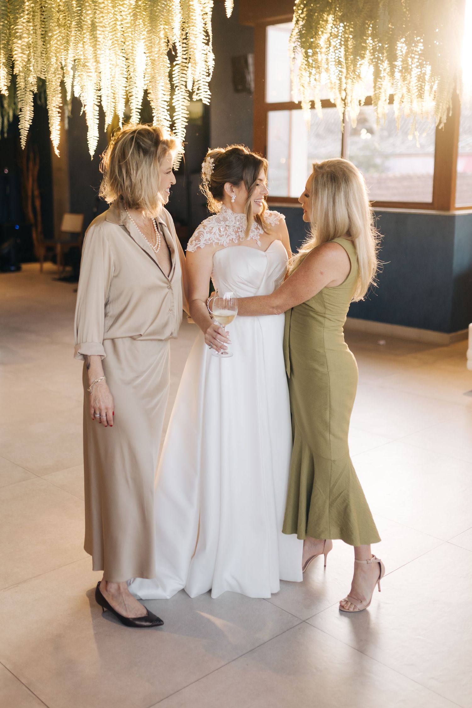 Wedding venue with hanging floral decor and guests in elegant attire.