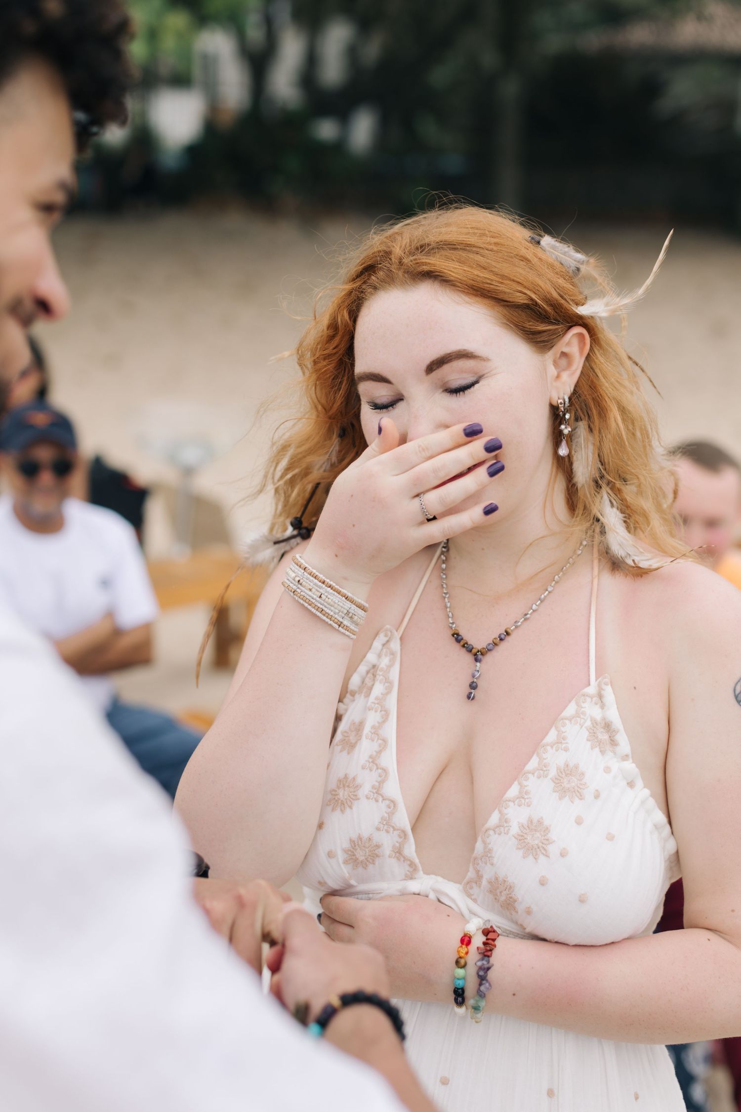 Emotional reaction during ring exchange at outdoor beach wedding ceremony.