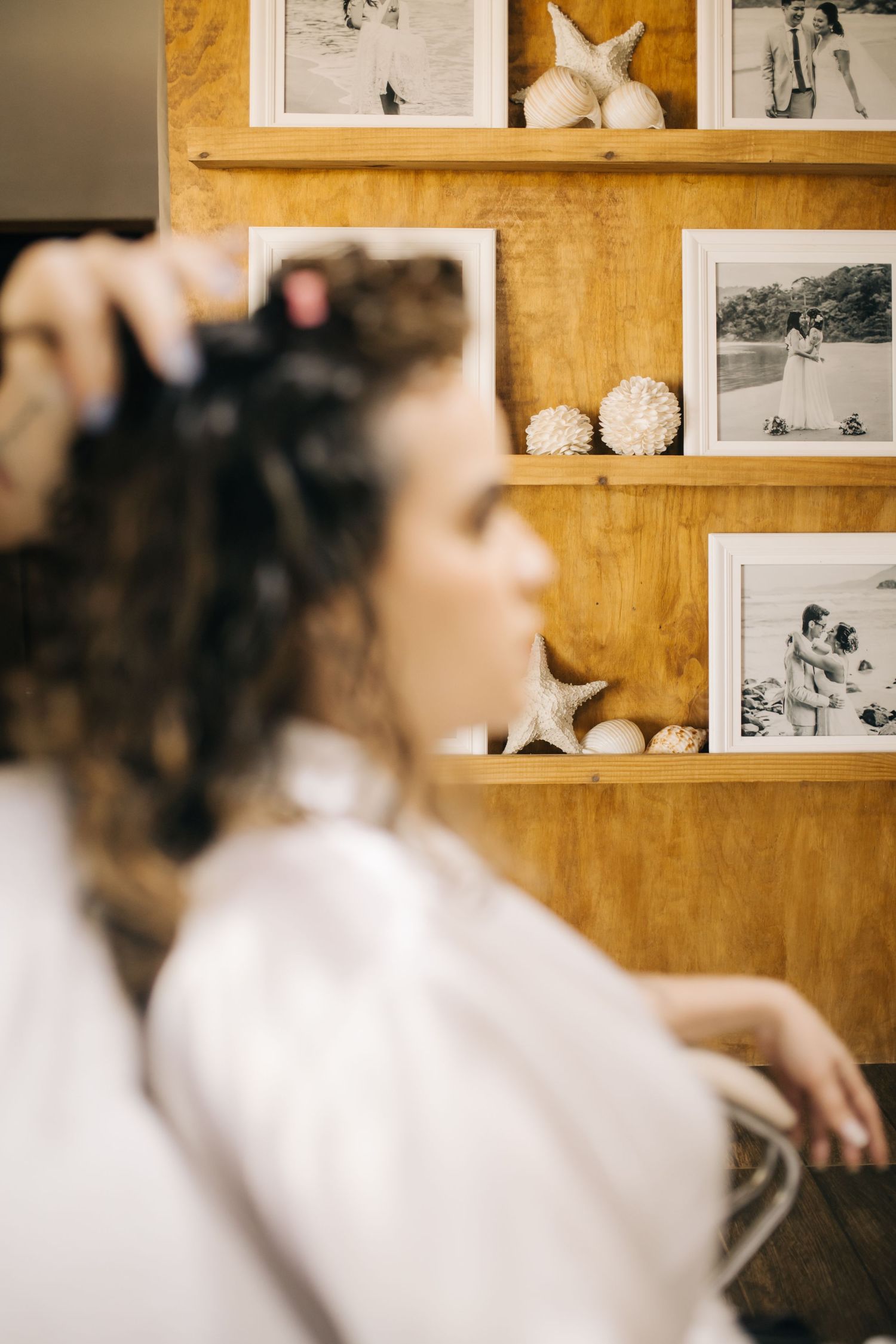 Wedding preparation displays with black and white photographs arranged on a golden wall.