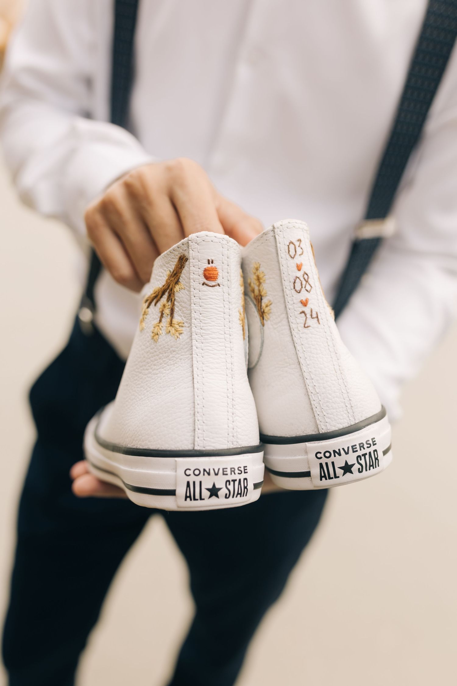 Customized white Converse All-Star sneakers with golden wedding-themed designs.