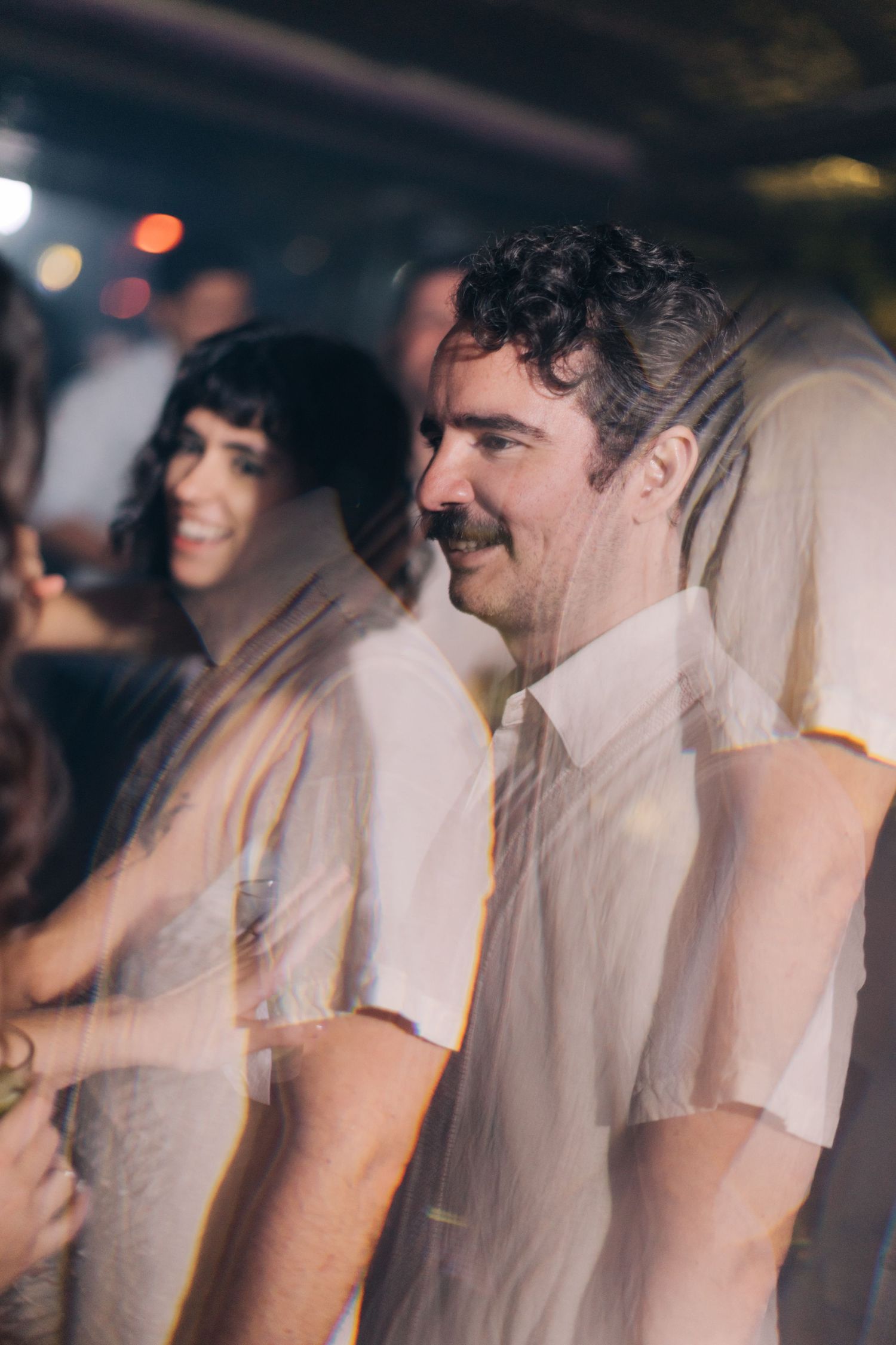 Party guests in white shirts enjoying themselves at an indoor celebration.