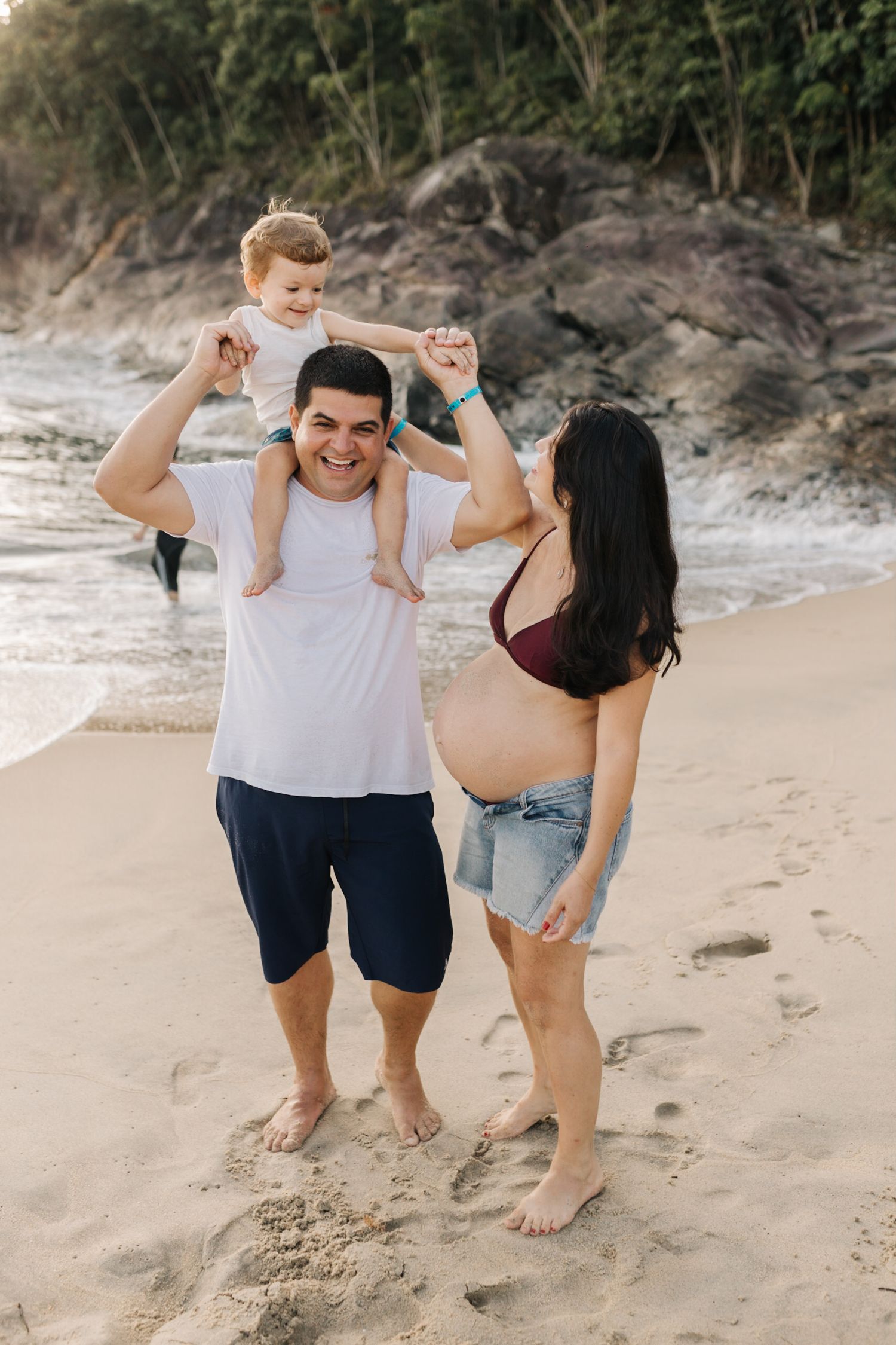 Barefoot family playing in the sand during a sunset beach photography session.