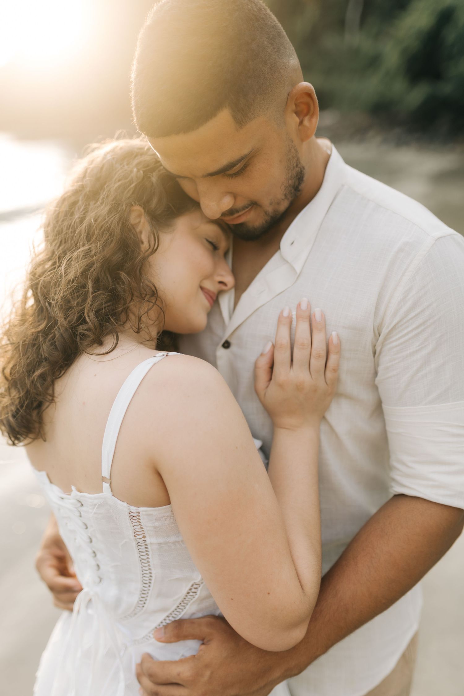 Intimate moment between couple during golden hour on a beach.