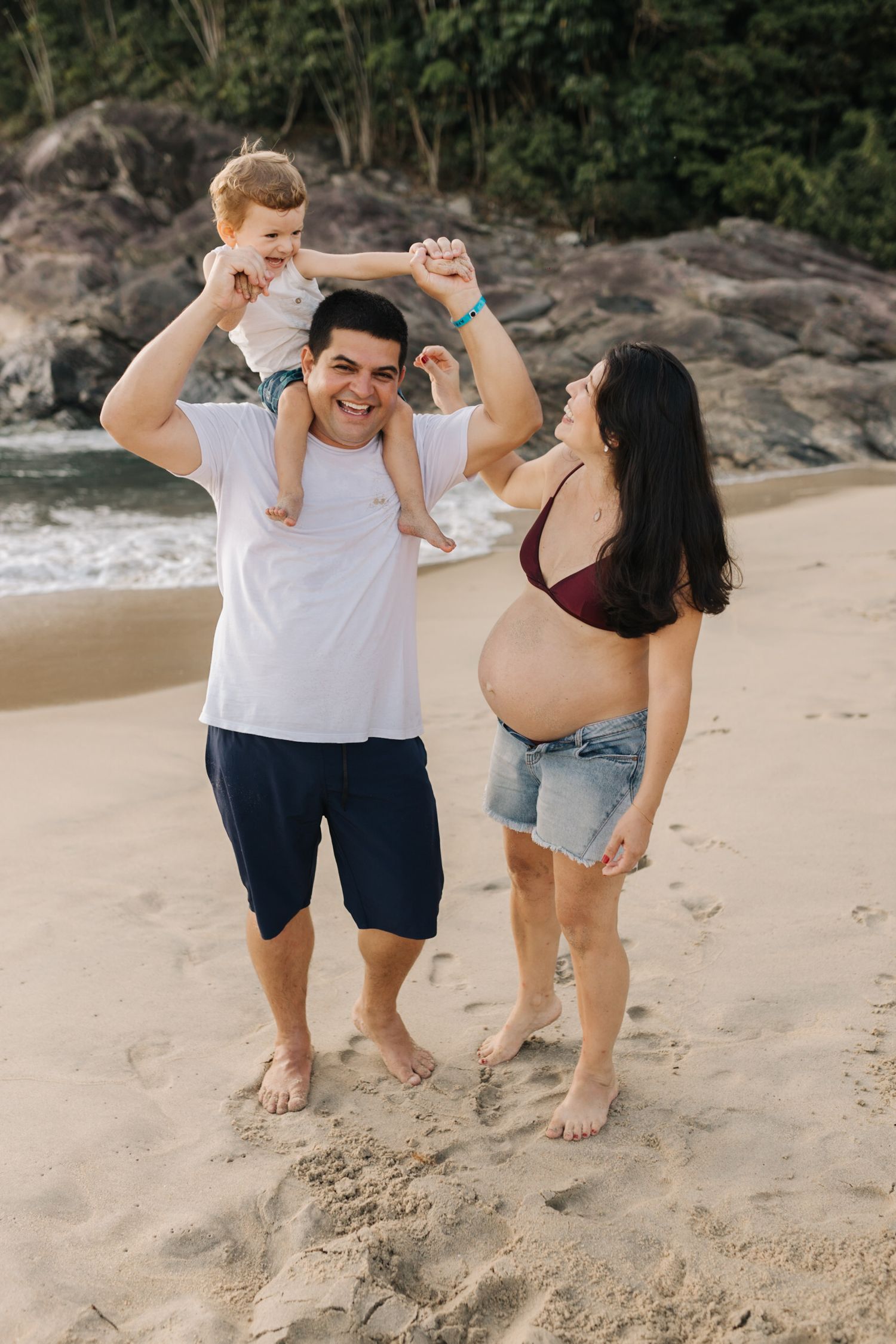 Casual beach photo session showing family enjoying time together near rocky coastline.