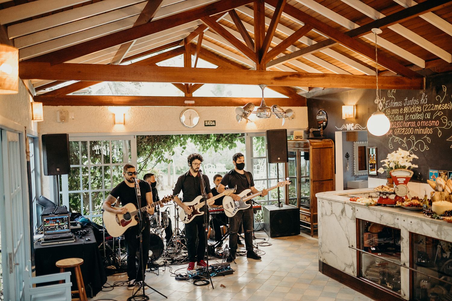 A rustic wedding reception venue interior featuring exposed wooden beams and warm lighting.