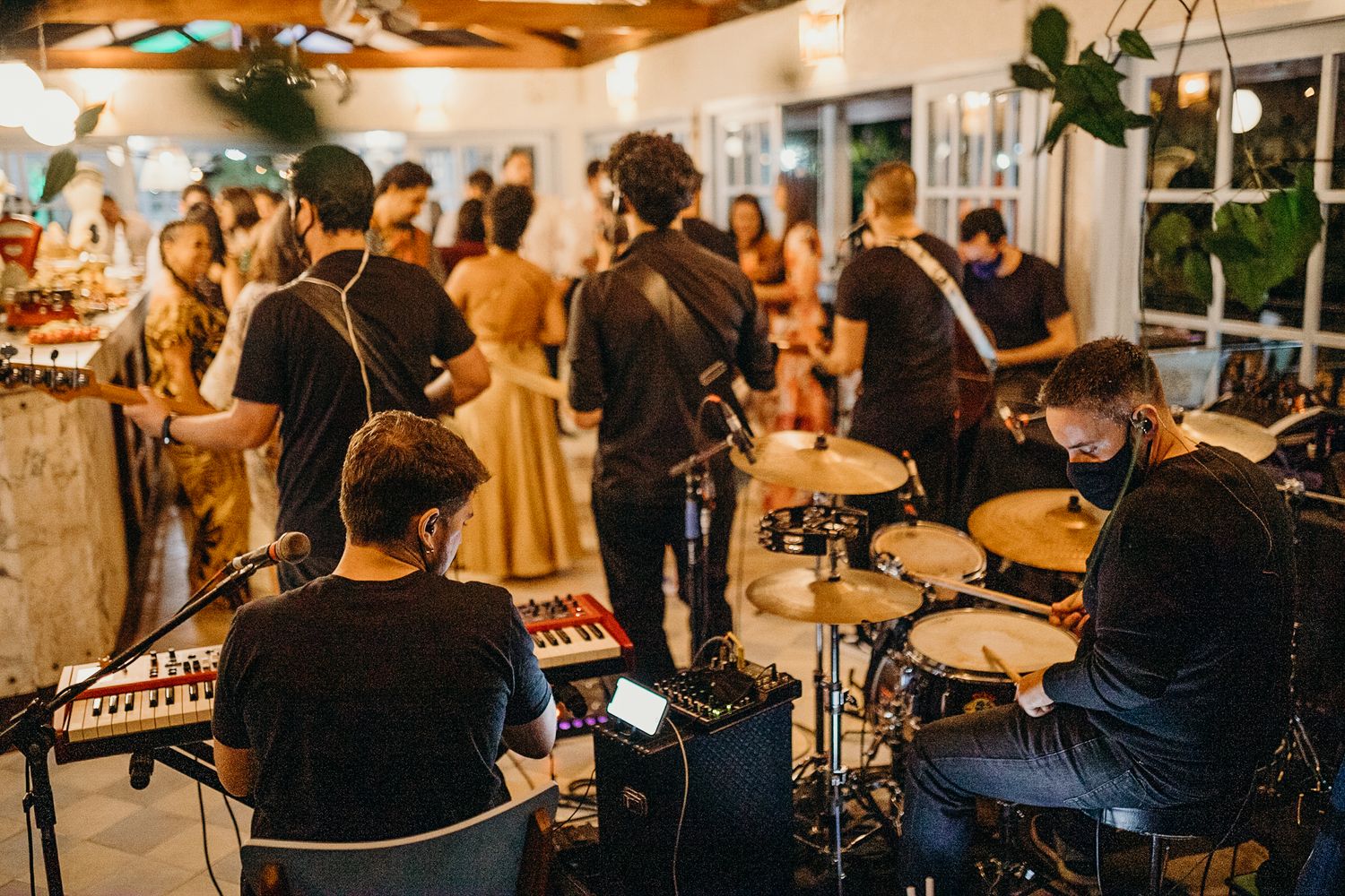 Guests mingle at an indoor reception venue with warm lighting and a cozy atmosphere.