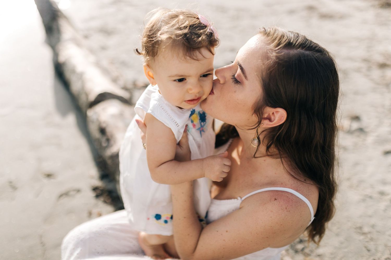 A tender moment shared between parent and child on a sunny beach.