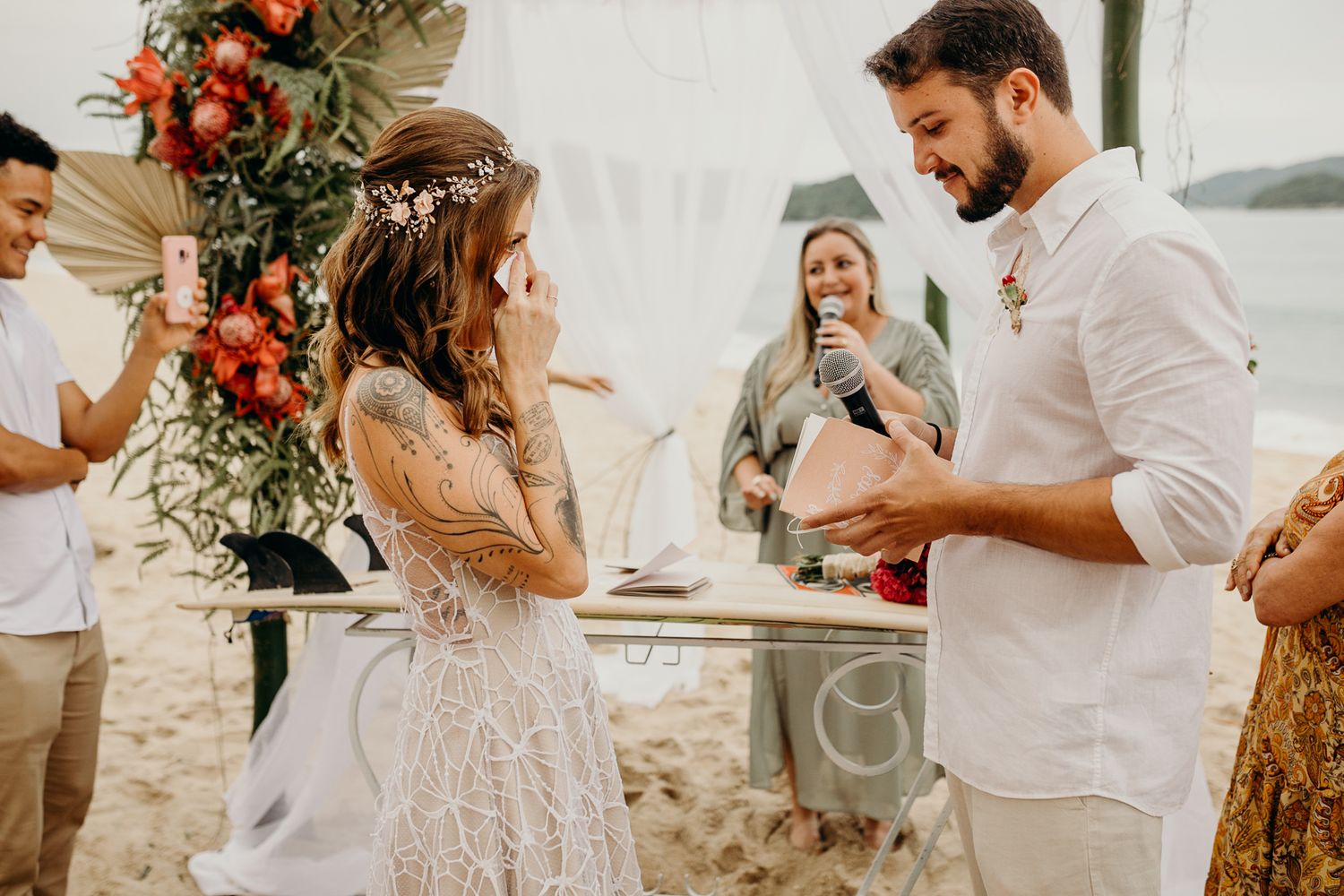 Rustic outdoor wedding ceremony with floral arrangements and natural backdrop.