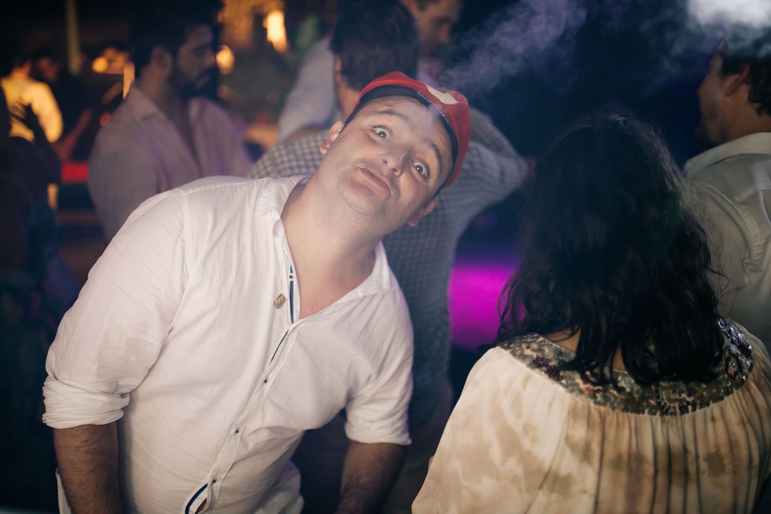 Party guests enjoying themselves at a dimly lit nightclub venue.