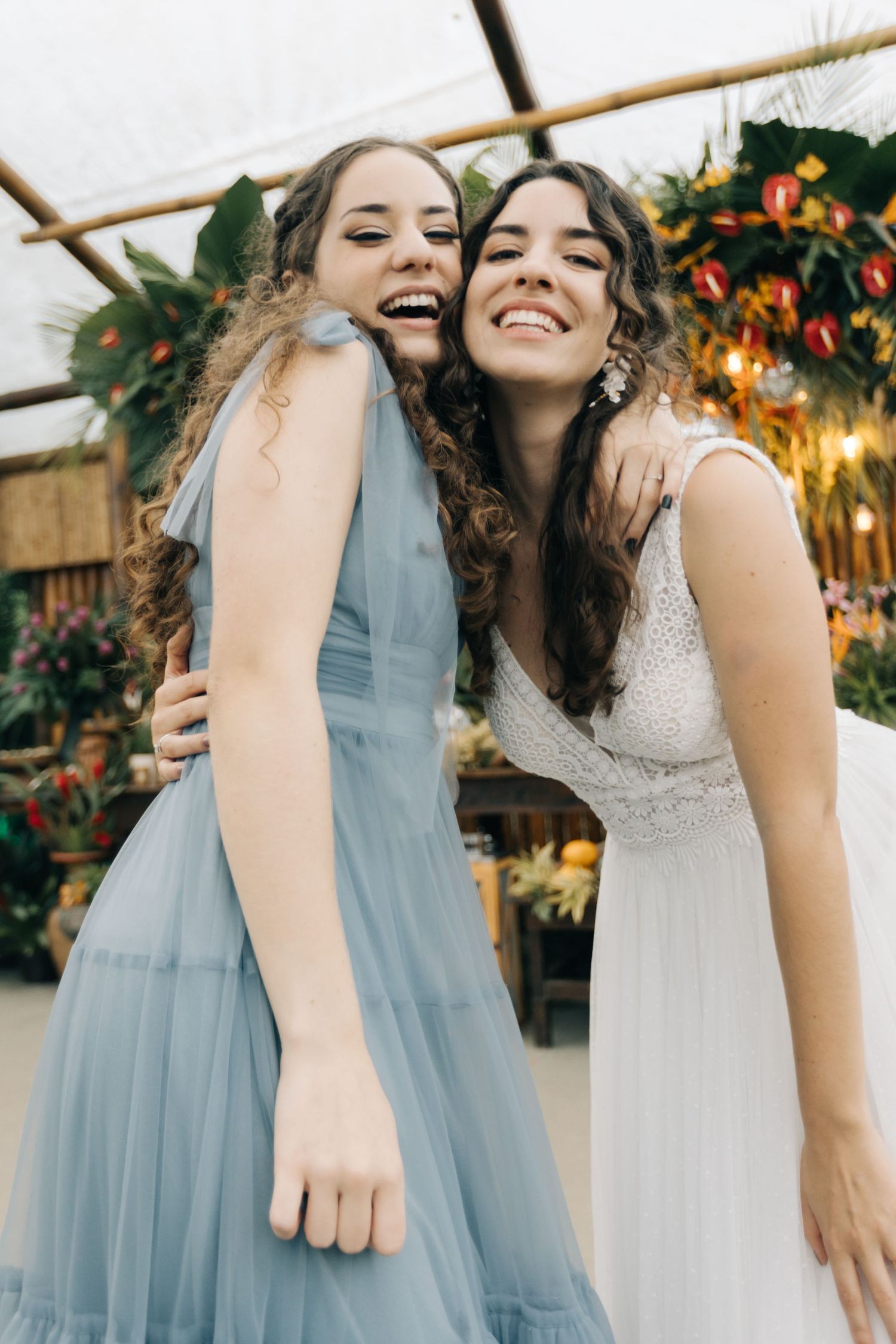 Two wedding attendees share an emotional embrace during a reception celebration.