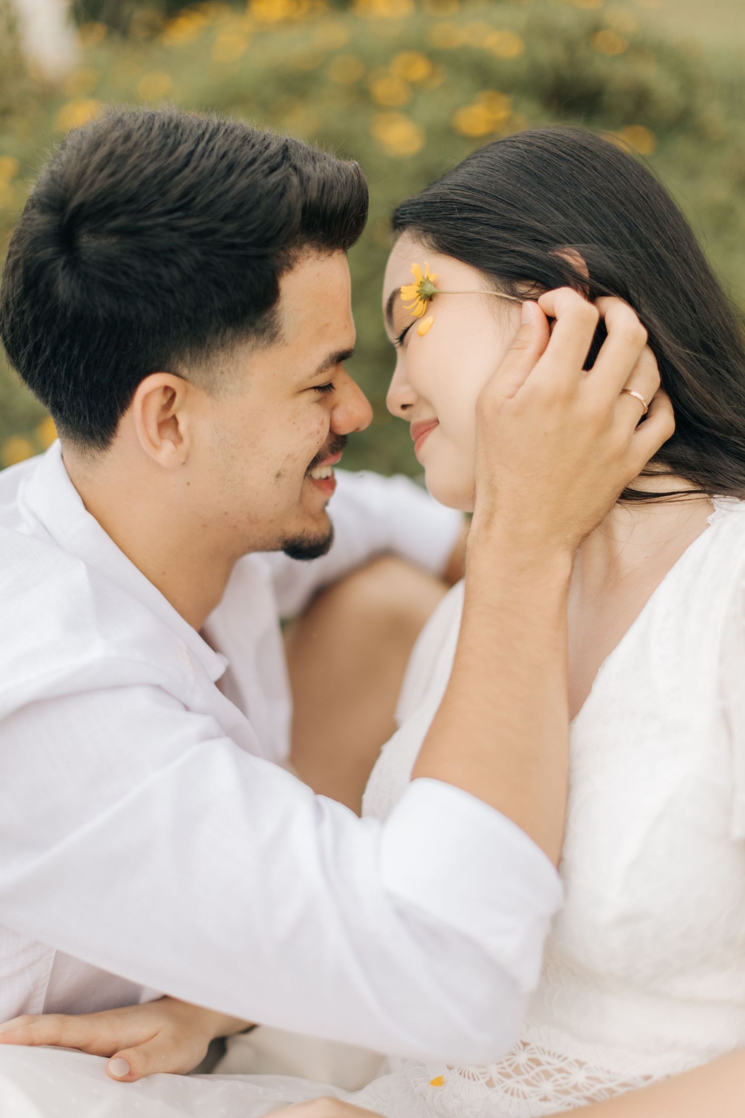 Intimate close-up shots of couple sharing tender moments among flowers.