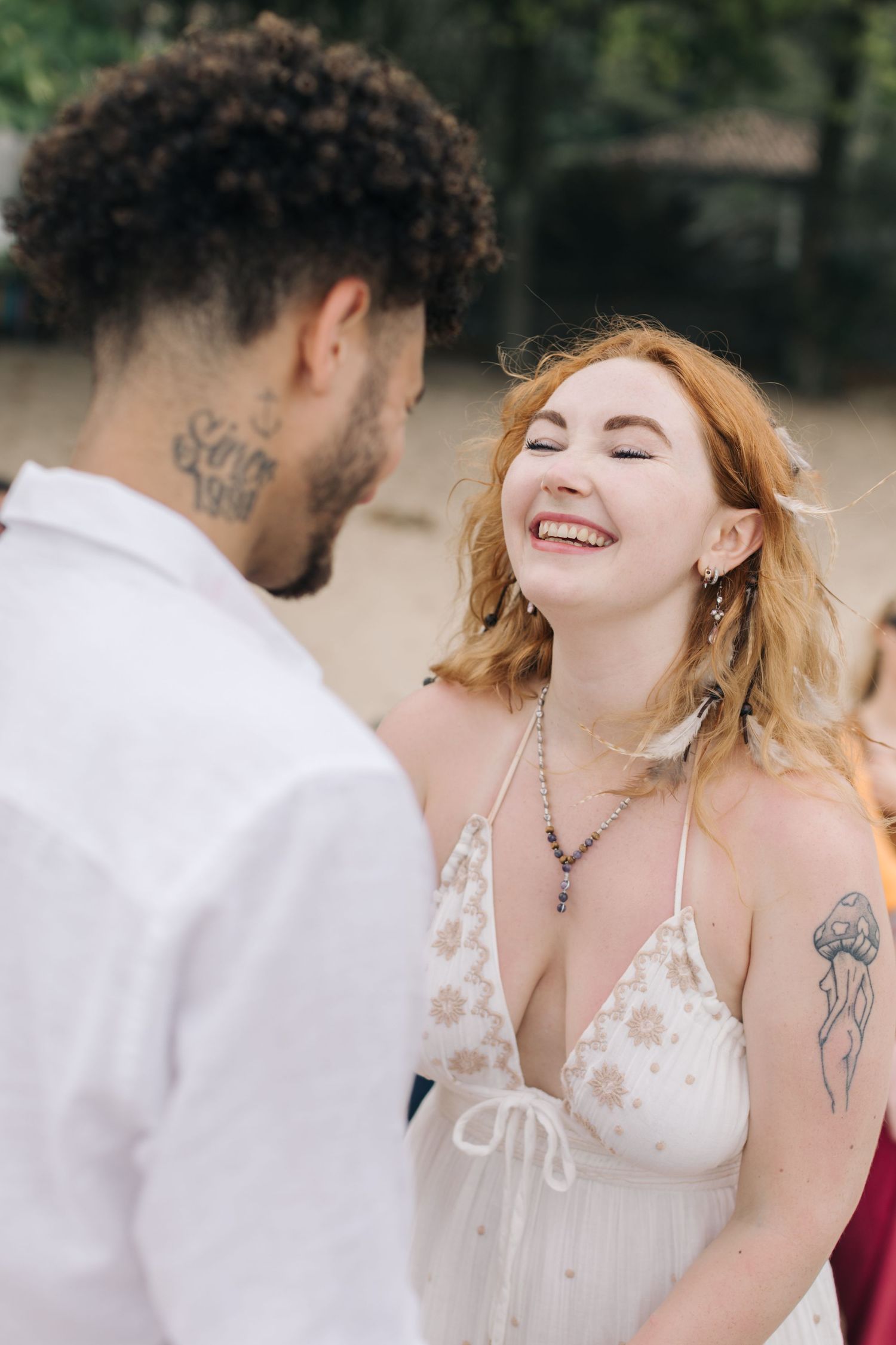 A joyful candid moment between a couple at their beach wedding ceremony.