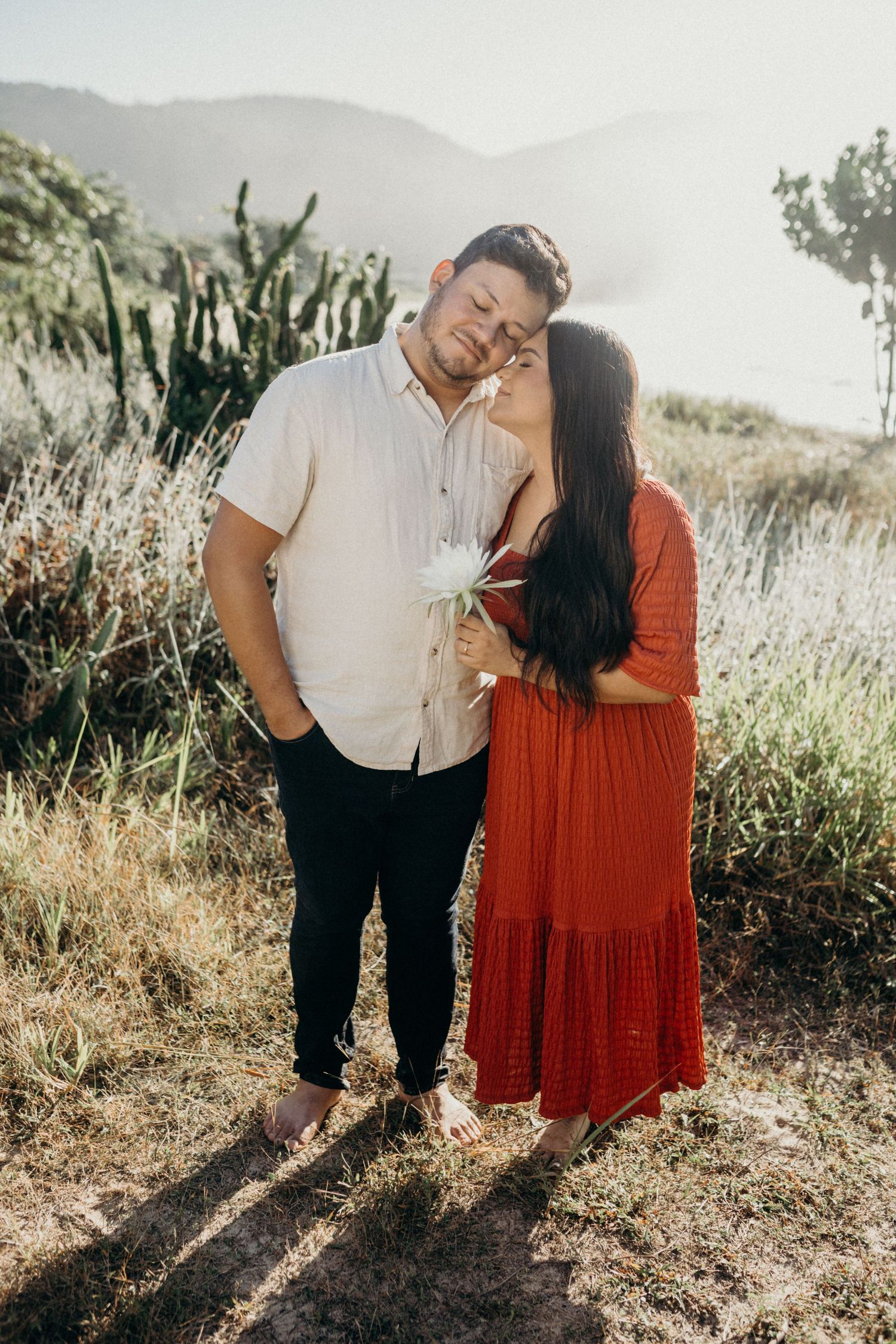 Intimate couple moment captured against mountainous backdrop during golden hour.