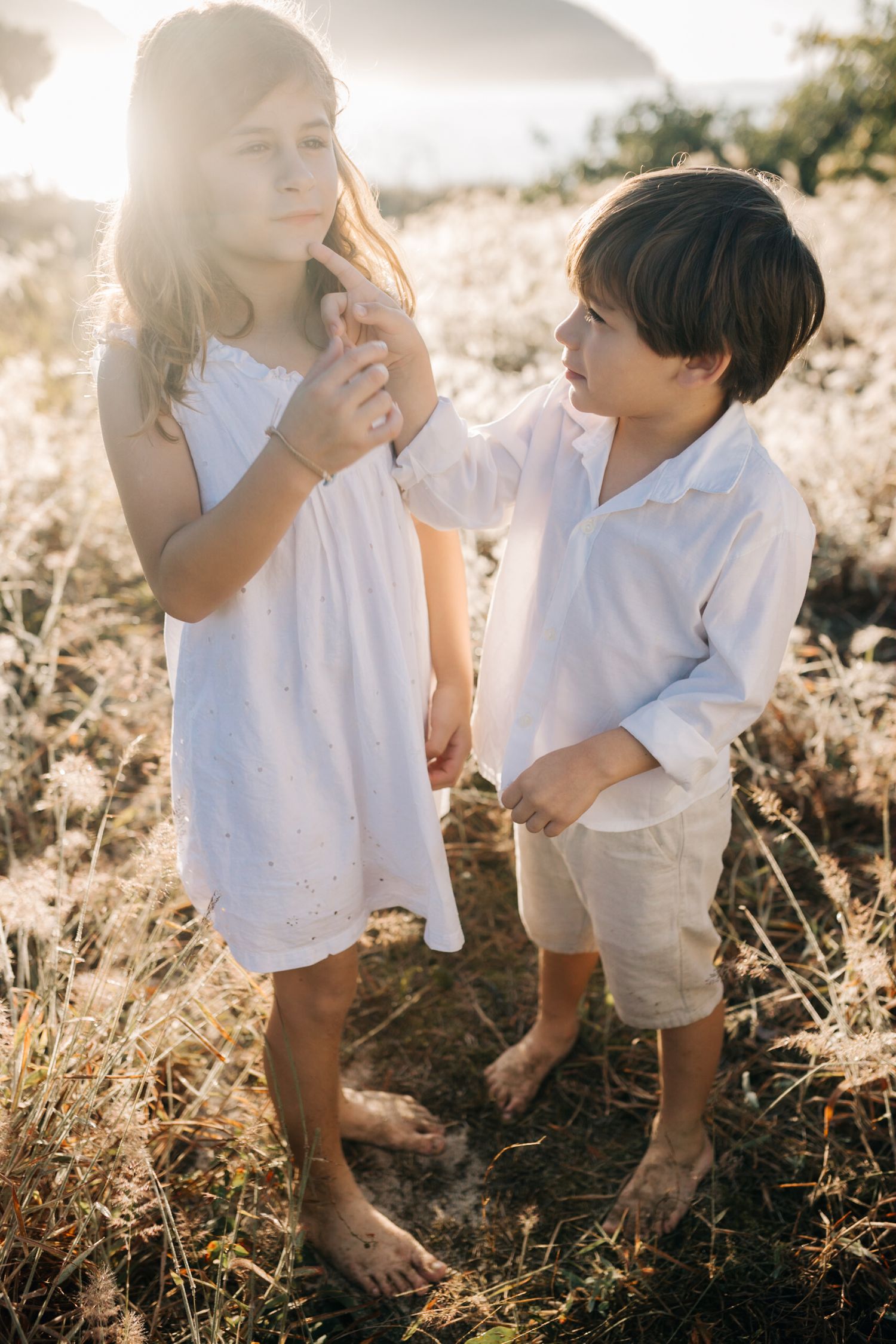 Close up view of small feet and legs standing in wild grass during sunset.