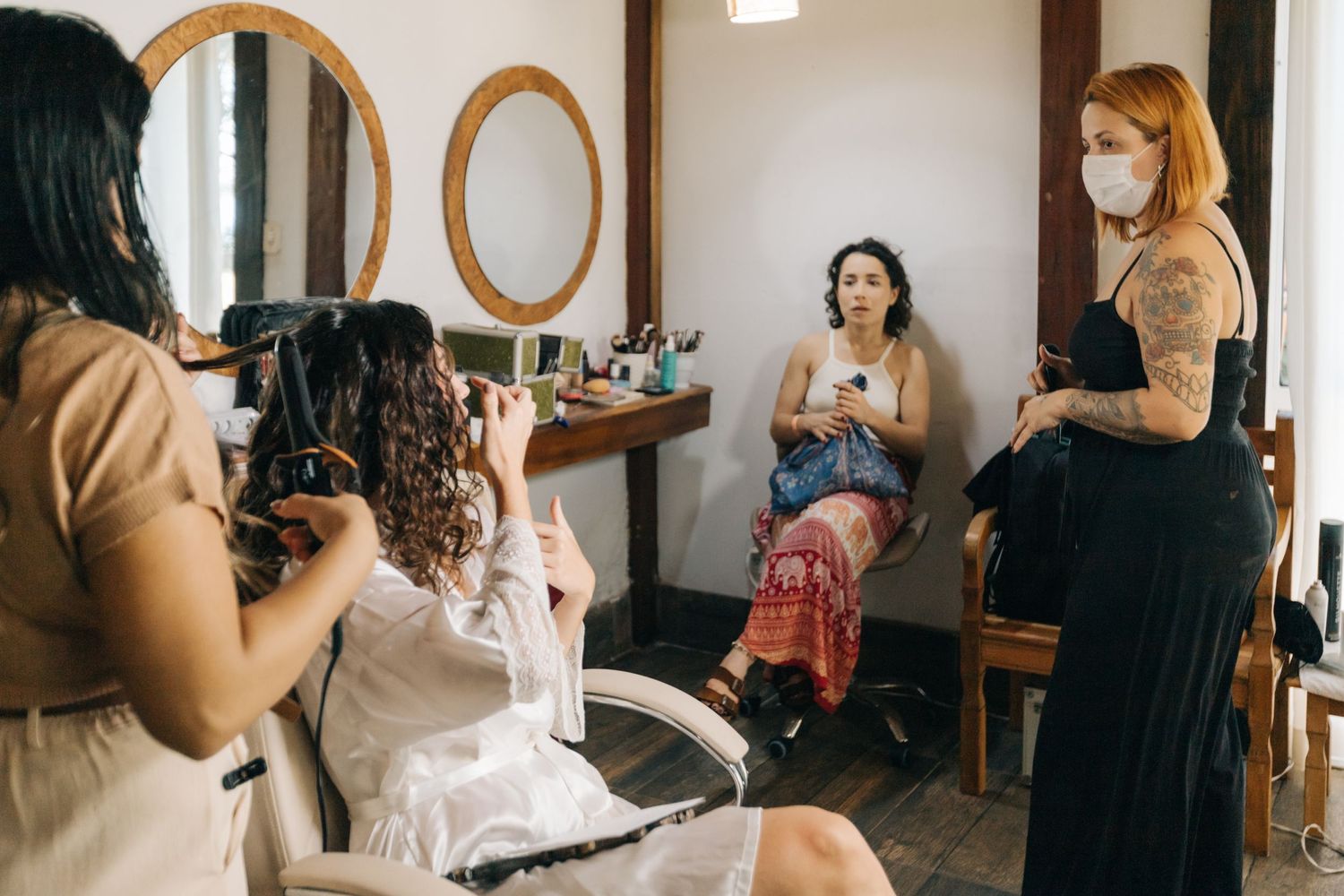 Getting ready scene with makeup artists and stylists preparing for a wedding.