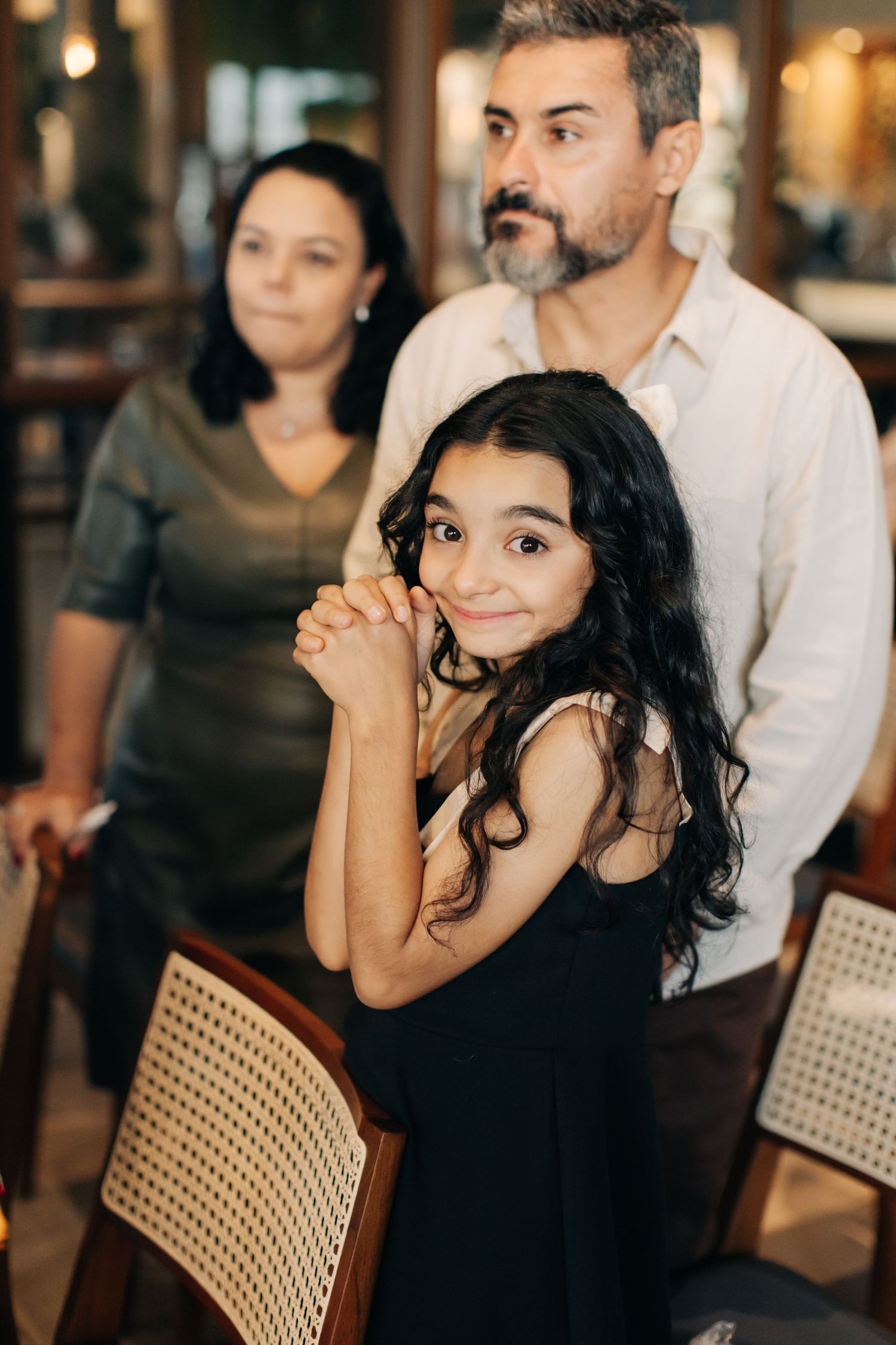 Wedding guests watching the ceremony with joyful expressions in an indoor venue.