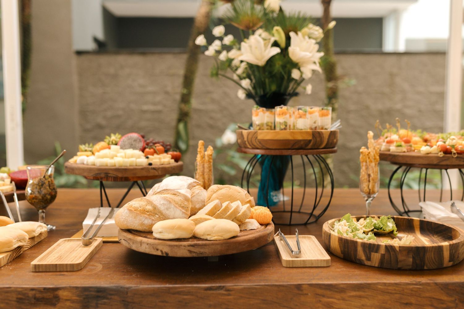 Elegant buffet table setting with sandwich platters and floral centerpiece at an event.