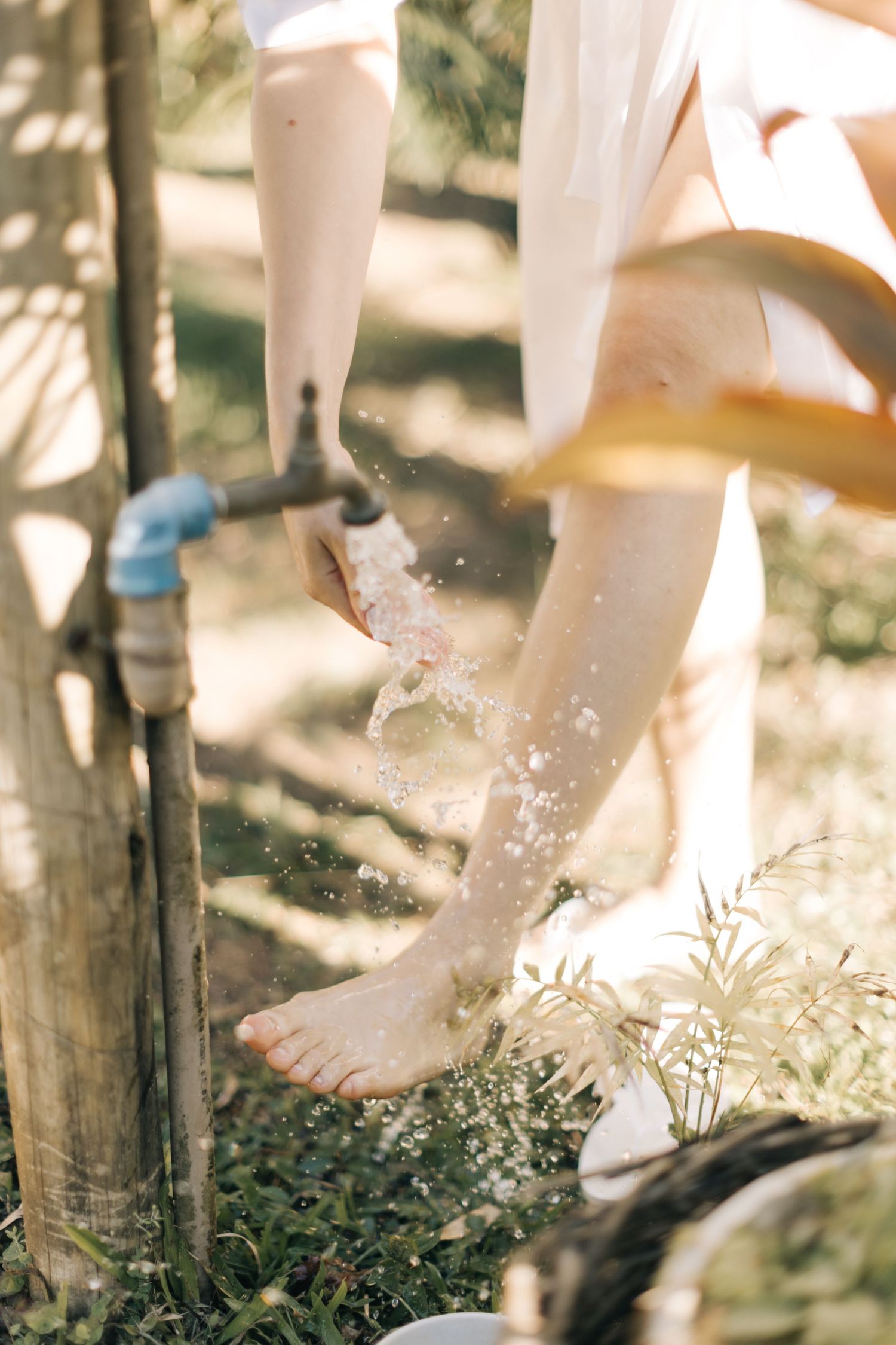 Artistic shot of bare feet against wooden post in natural sunlight.