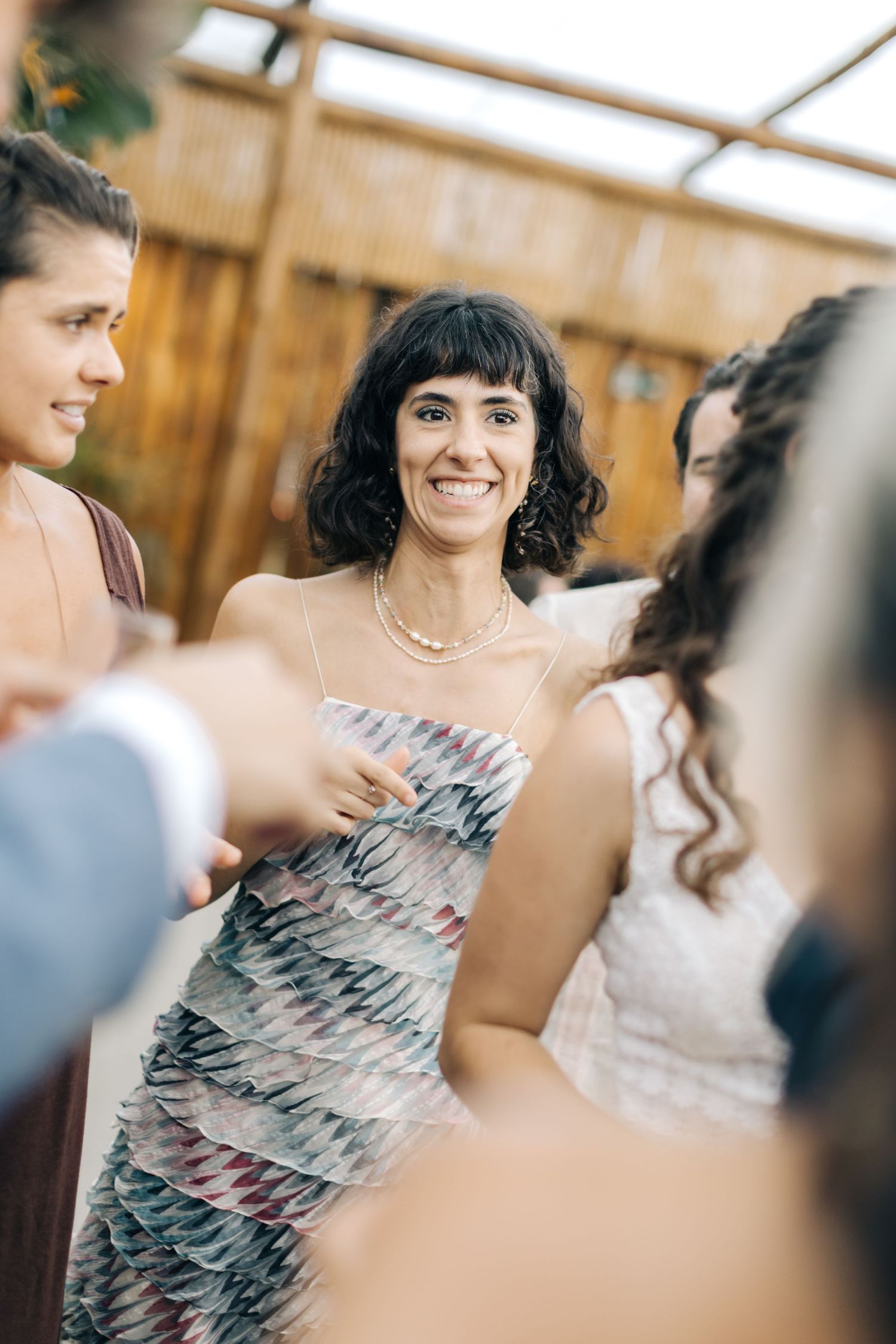 Wedding guest in a patterned dress enjoying the celebration at an outdoor reception.