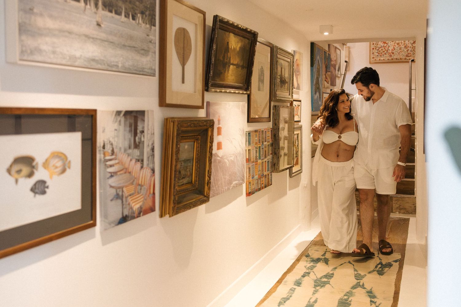 Gallery visitors admire artwork displayed on white walls in a modern exhibition space.