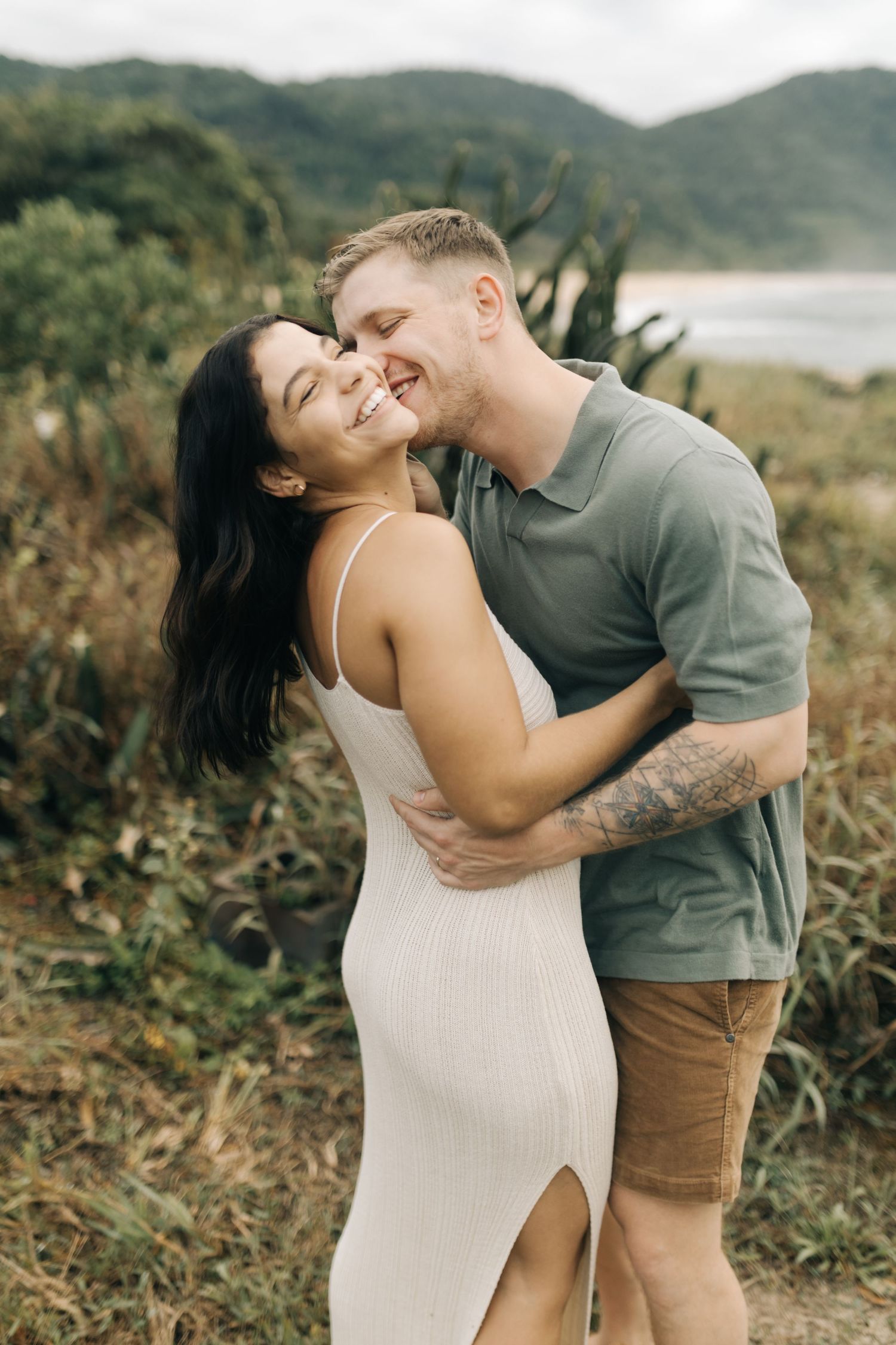 A couple shares playful and romantic moments together during an outdoor photoshoot.