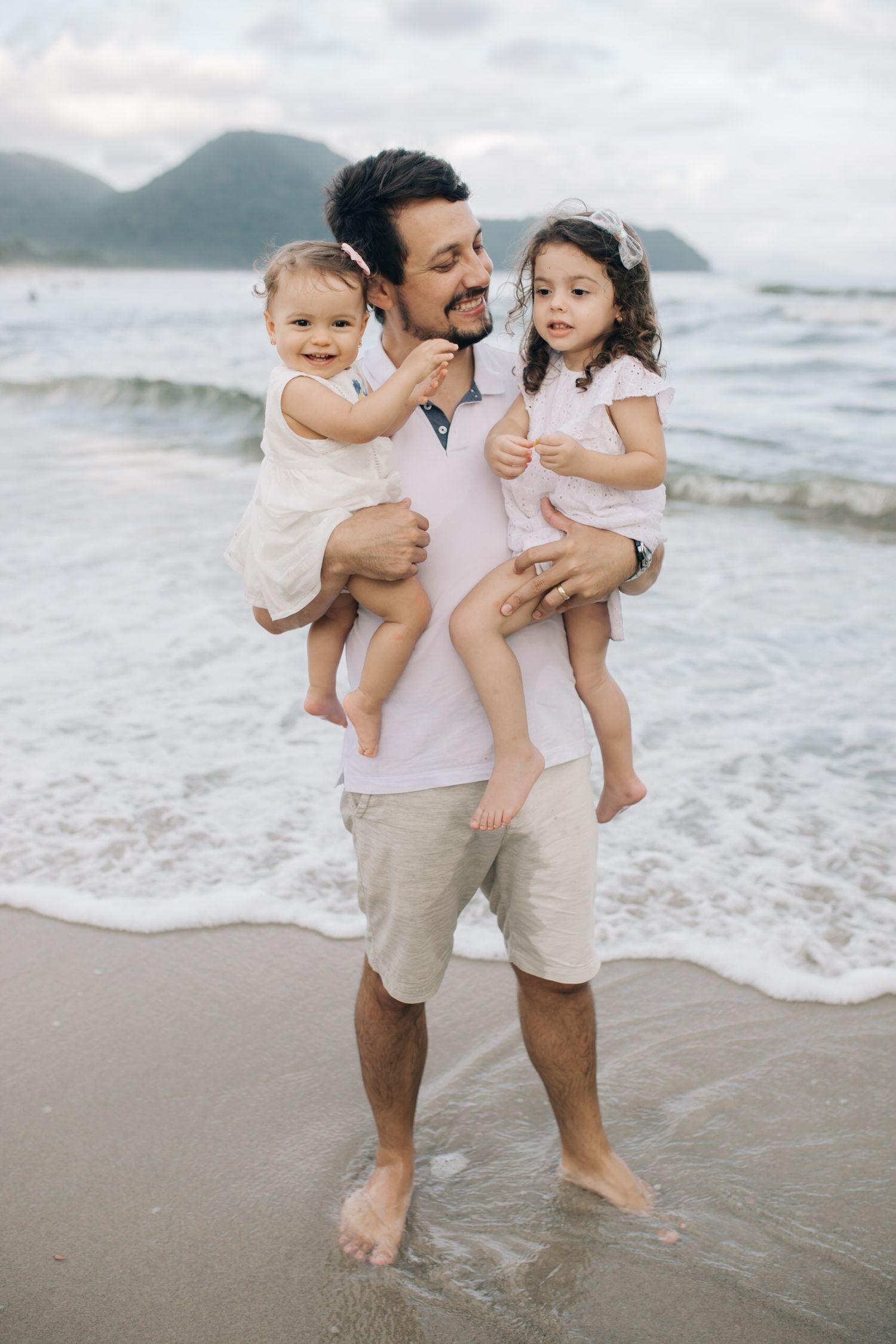 A family plays and laughs together in the ocean waves.