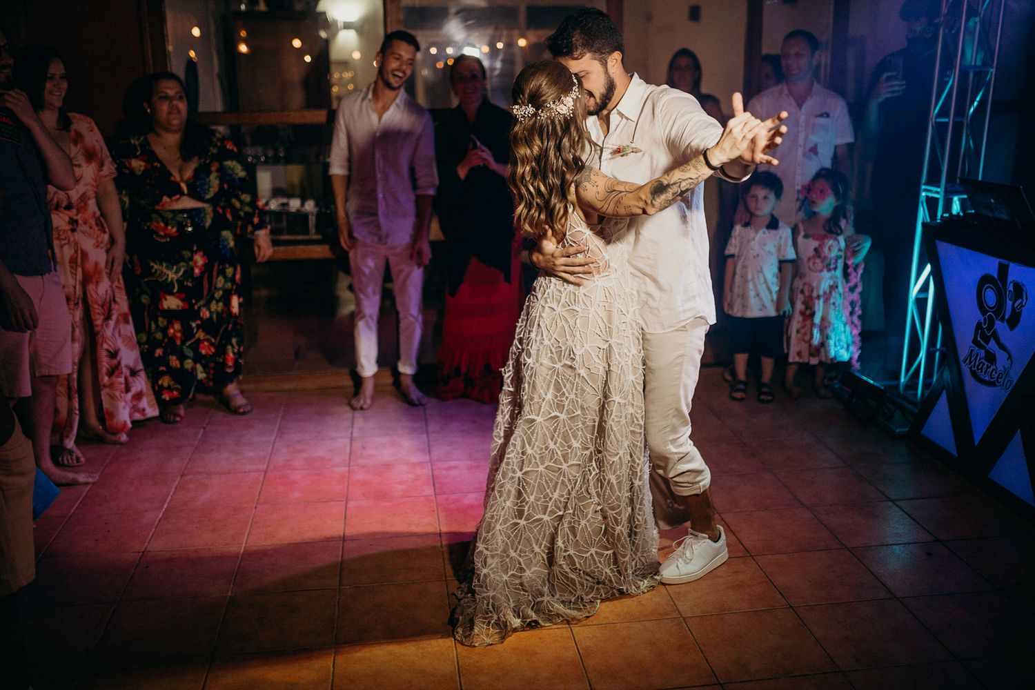 Wedding party dancing in formation during an evening reception with ambient lighting.