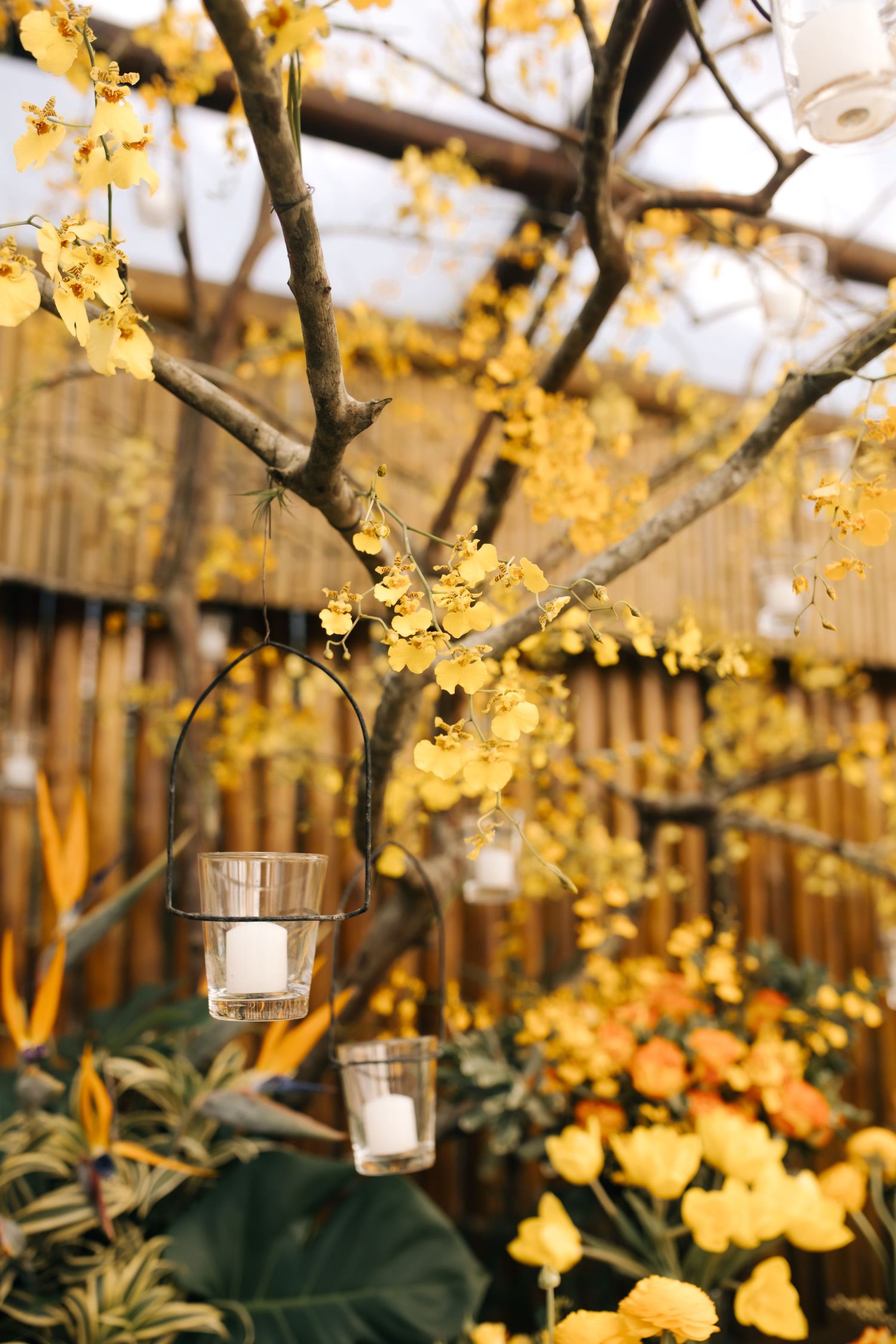 Enchanting garden setting with yellow flowers and hanging glass candle holders.