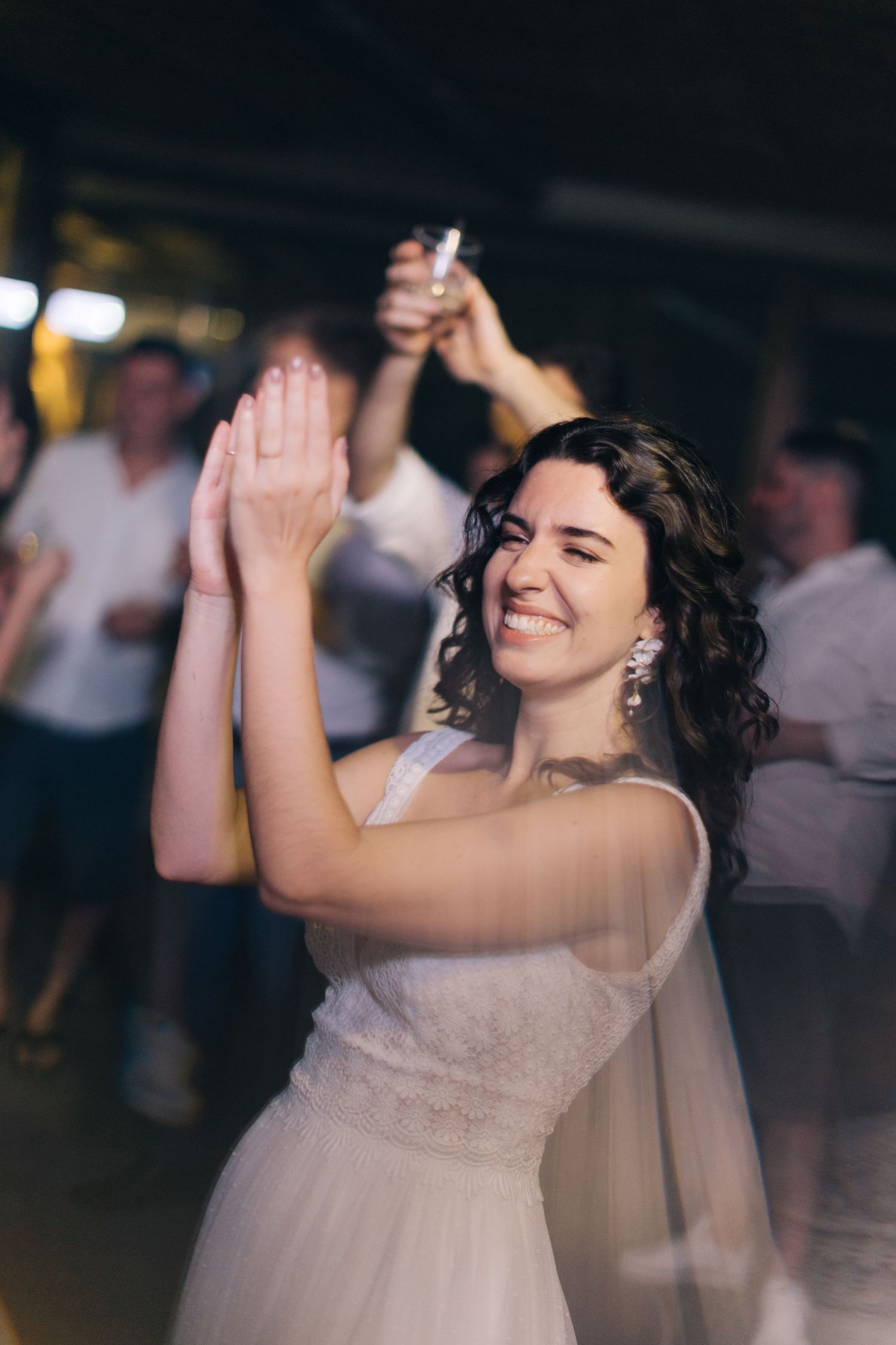 A person in a wedding dress claps and dances during the reception celebration.