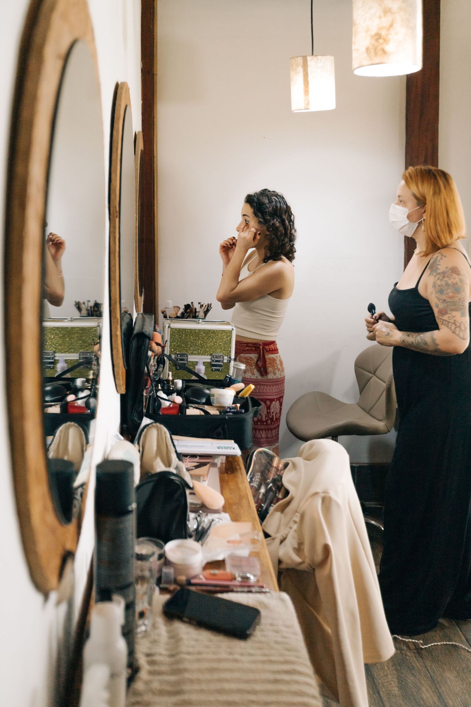 Women preparing for a special event in a room with large mirrors.