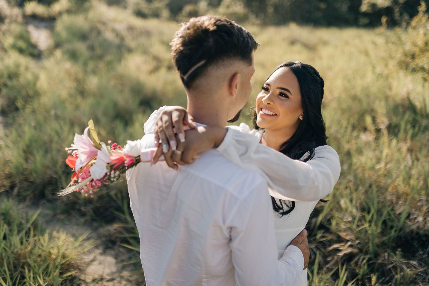 Tender moments captured between a couple in white clothing during a nature photoshoot.