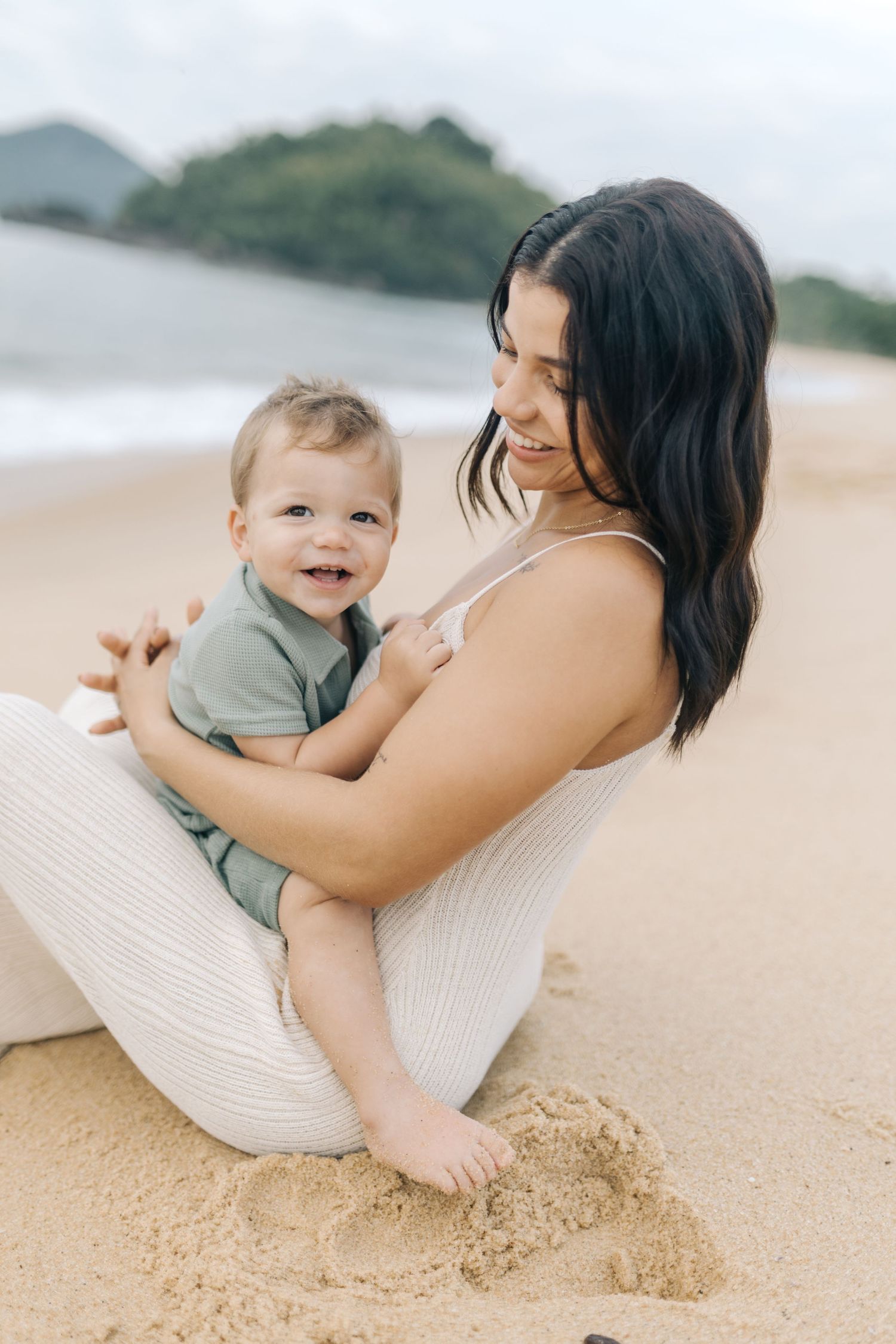 Sweet beach moments between parent and child while relaxing in the sand.