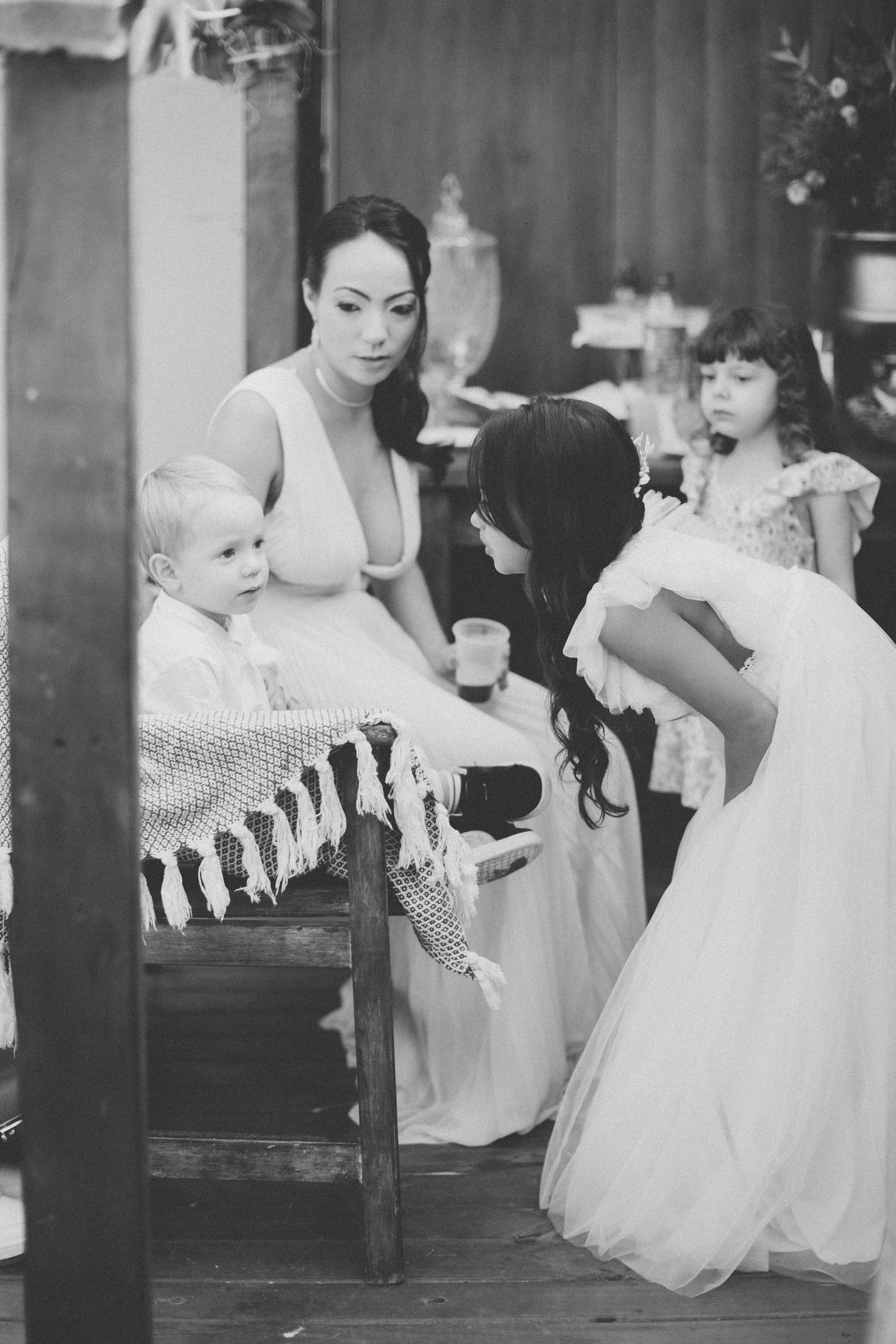 Black and white image of wedding preparations with children in formal attire.