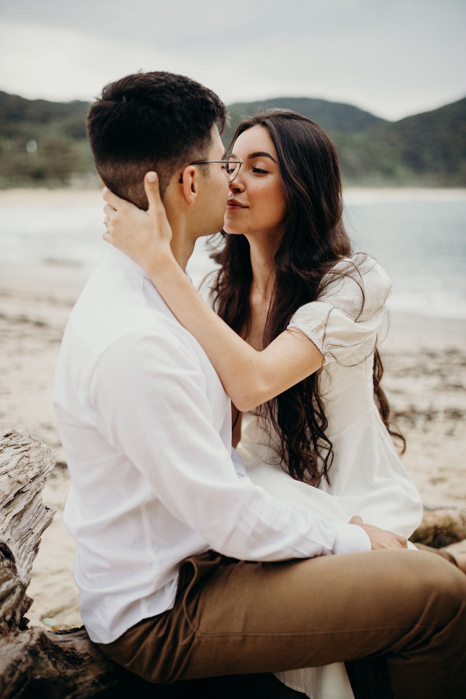 Intimate beachside portraits with mountain and ocean backdrop.