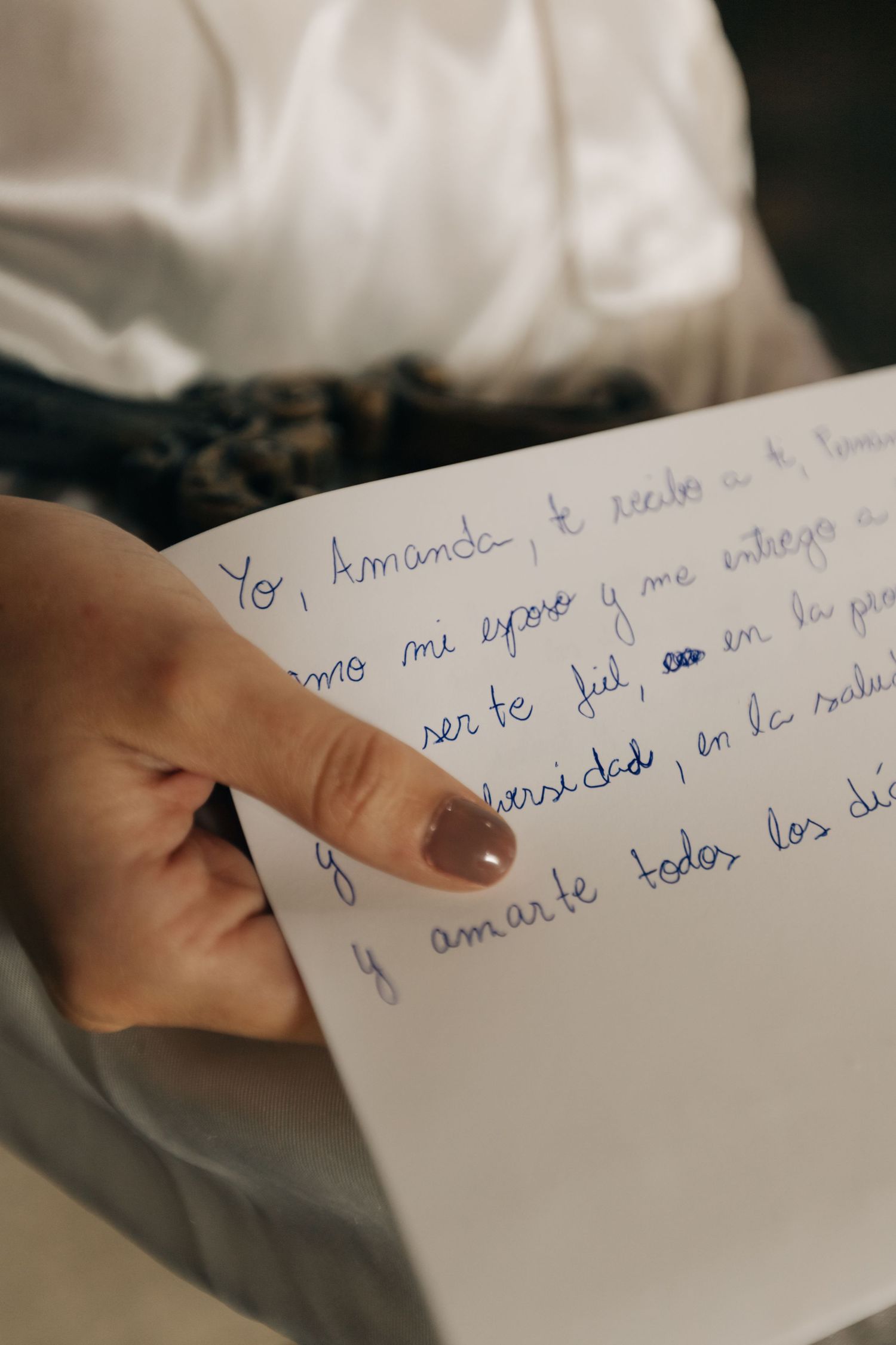 Close-up shot of hands holding a handwritten letter in blue ink.