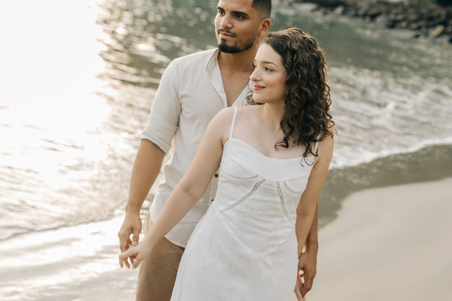 Couple sharing joyful moments during their beach sunset photoshoot.