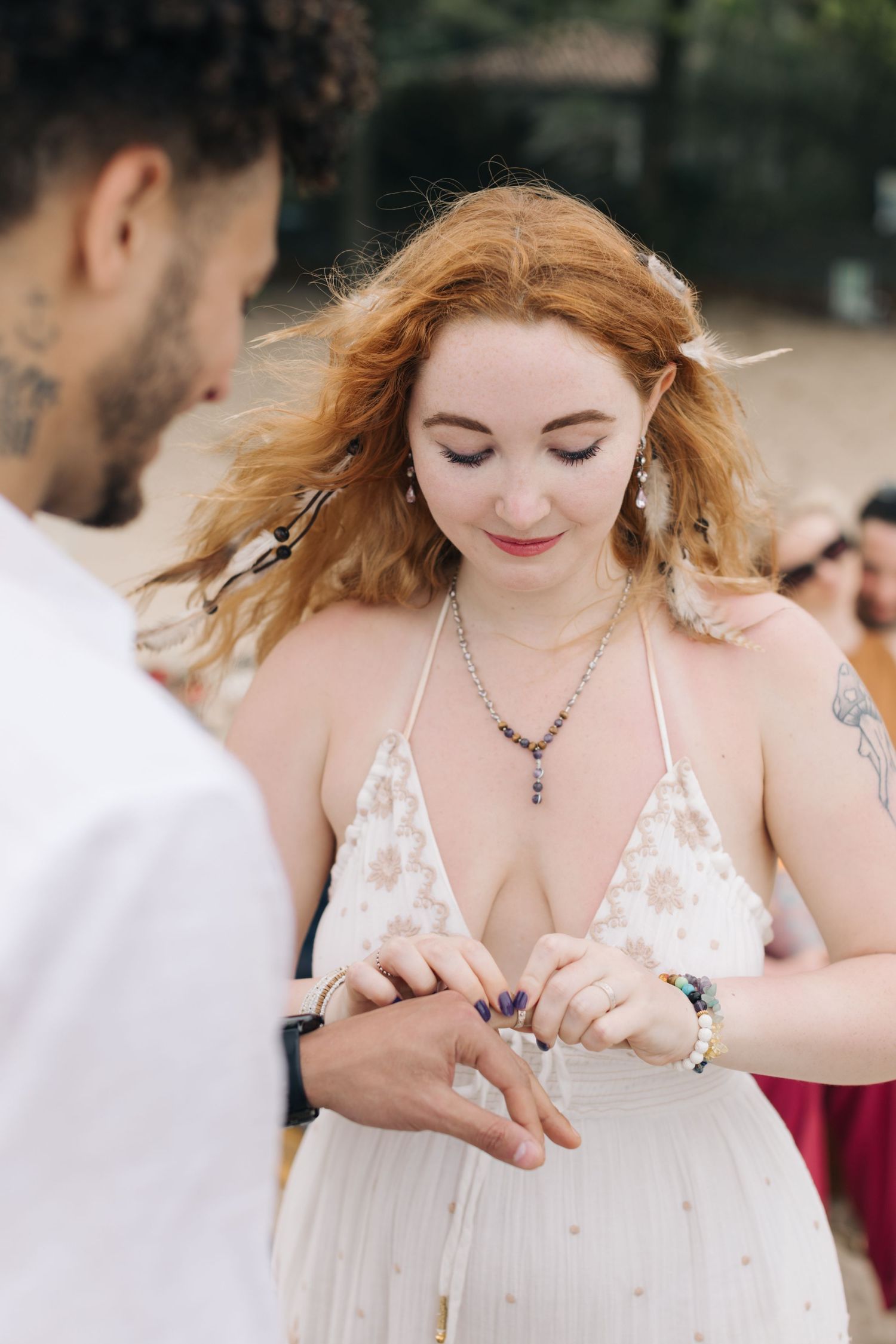 Intimate moment during ring exchange at outdoor wedding ceremony.