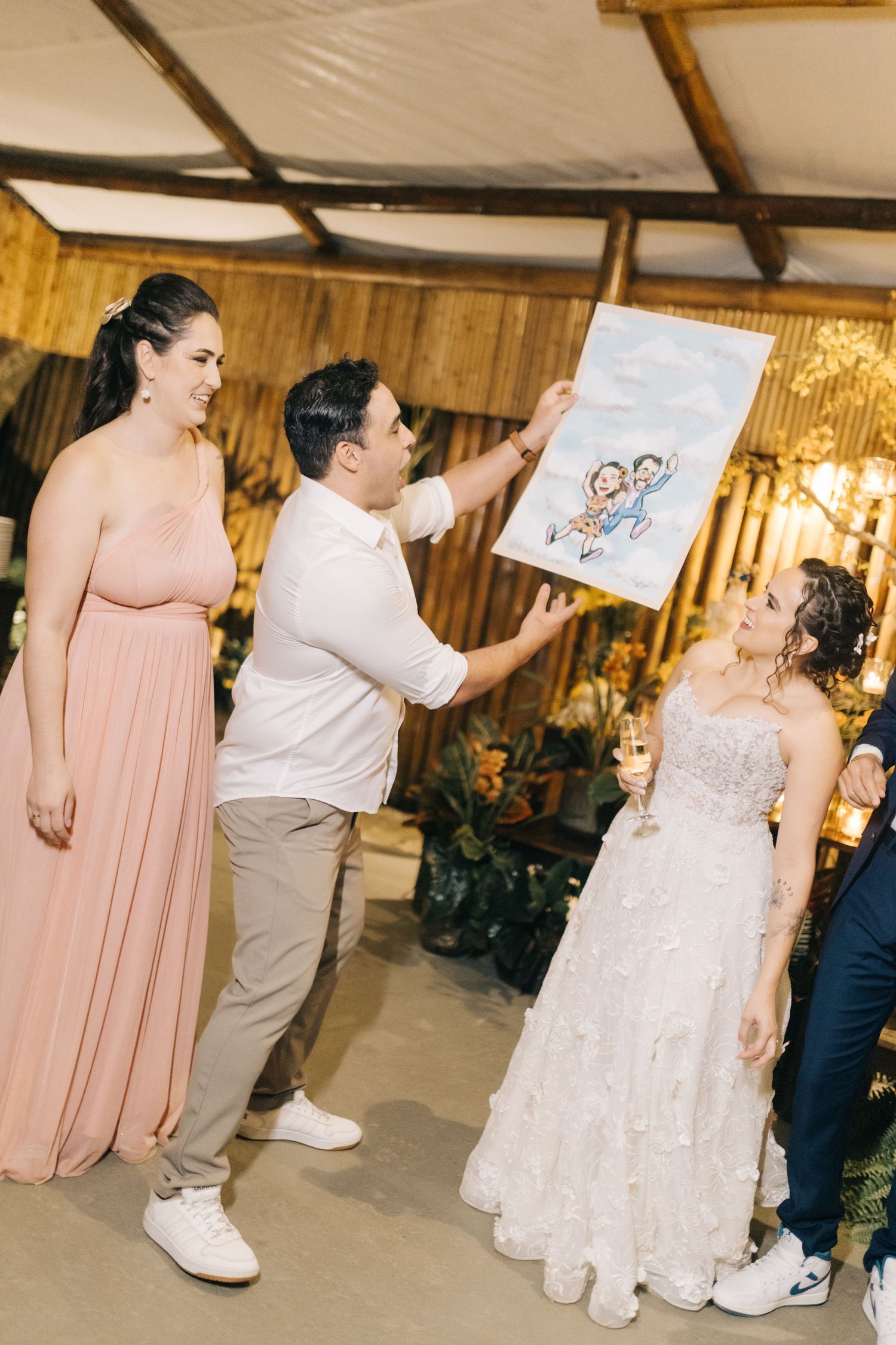 Wedding guests dance and celebrate in a rustic barn venue with blush pink decor.
