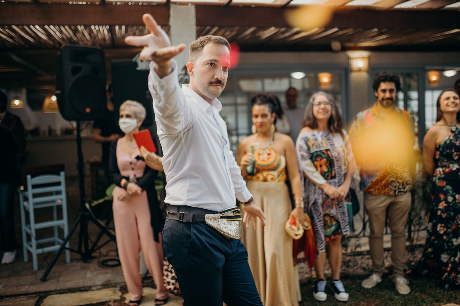 Celebratory moment captured at outdoor venue with guests under covered patio area.
