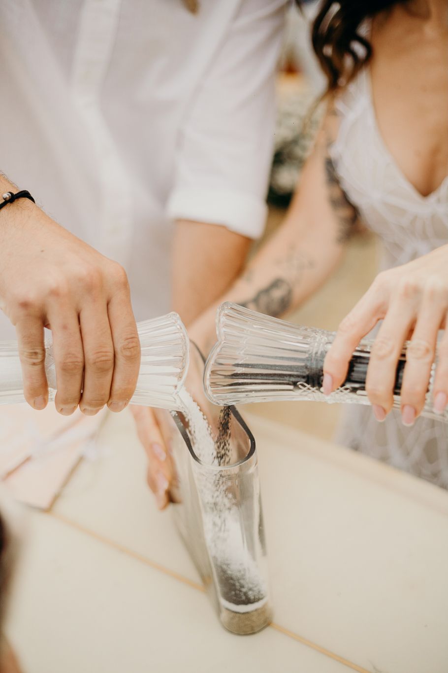 Detailed shot of crystal decanters being poured together in a unity ceremony.