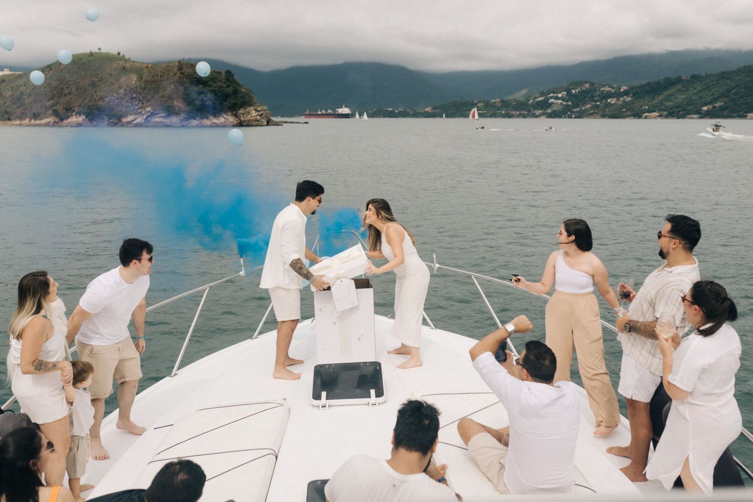 Special moment captured on a yacht deck with blue smoke and scenic mountain views.
