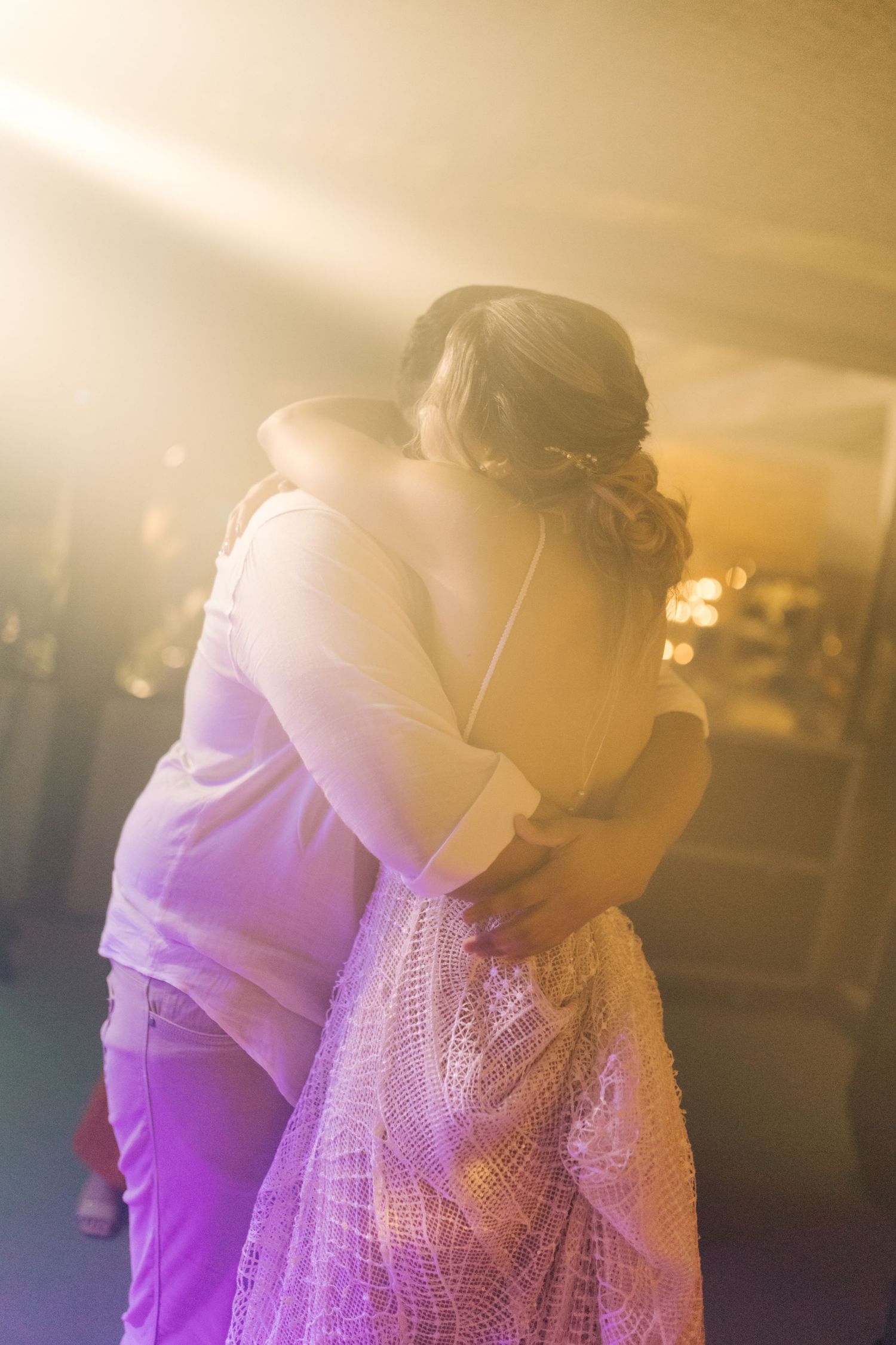 Intimate moment captured as two people embrace during a celebration.