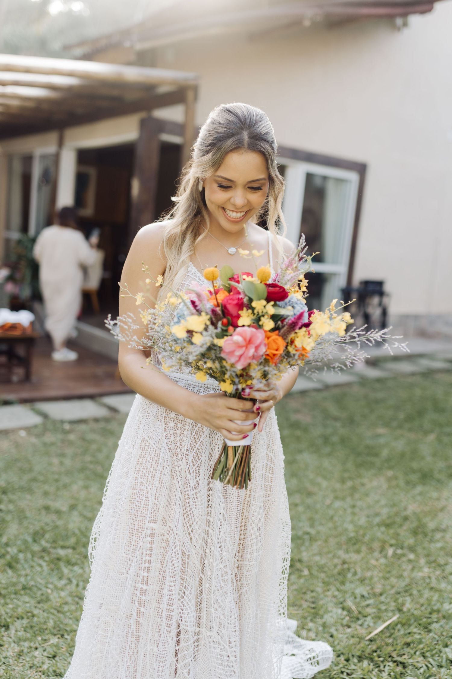A stunning bridal portrait showing a vibrant bouquet of mixed flowers against a white dress.