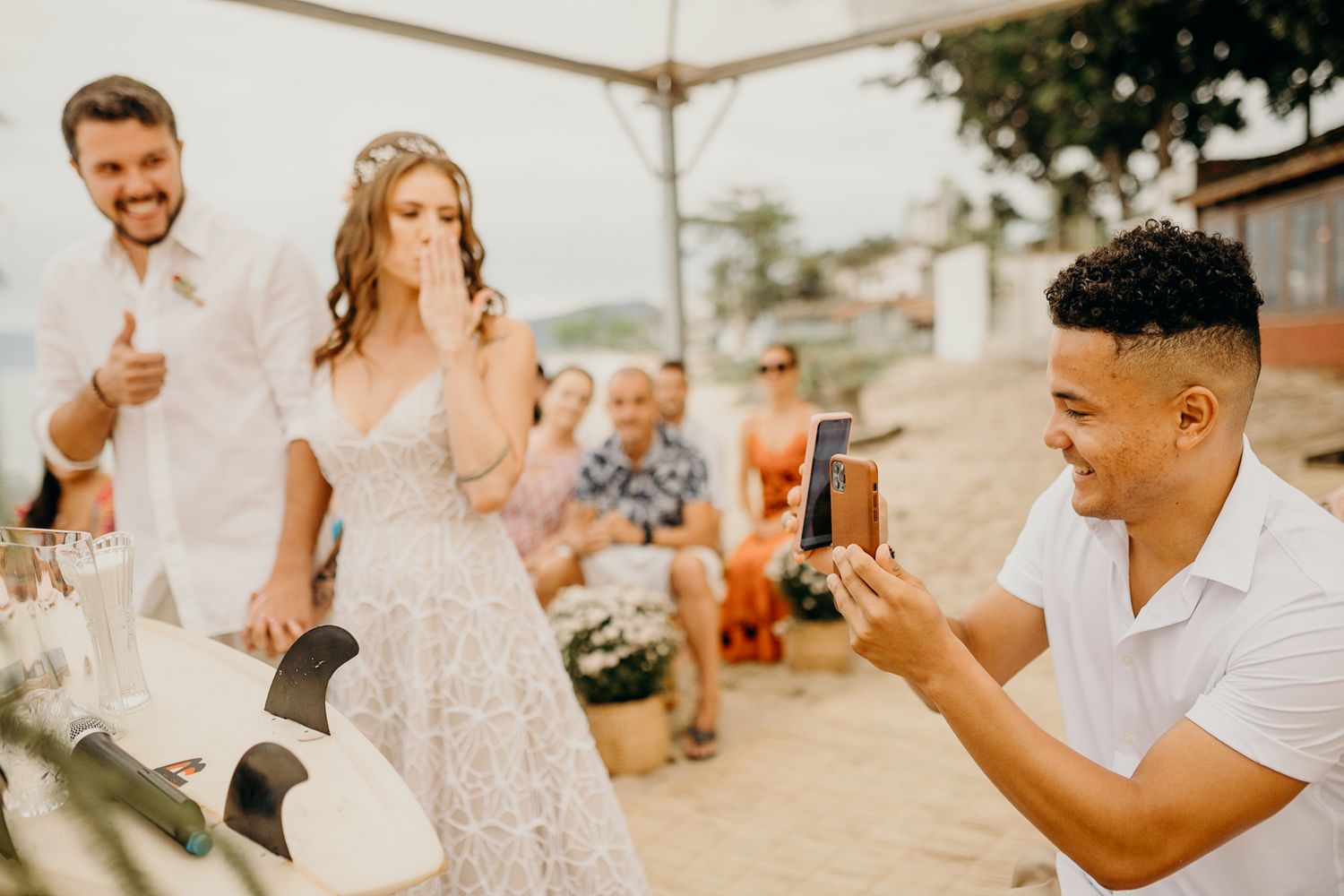 Beach wedding celebration with lace dress details and tropical decorations.