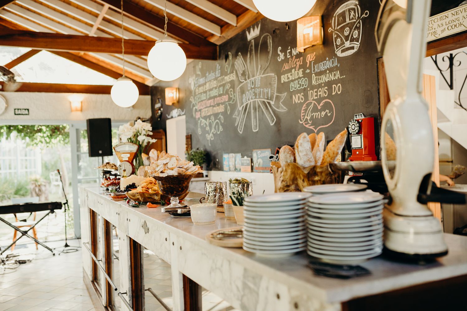 Modern restaurant interior with wooden ceiling beams and pendant lighting showcasing buffet setup.