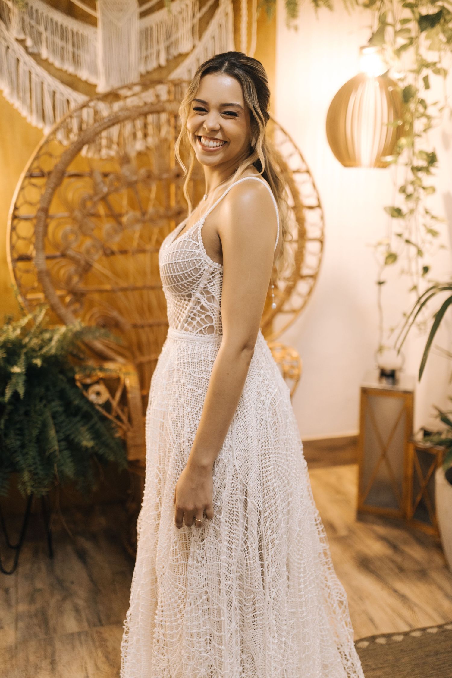 Ethereal white bridal gown with detailed lace patterns twirls gracefully in a golden-lit setting.