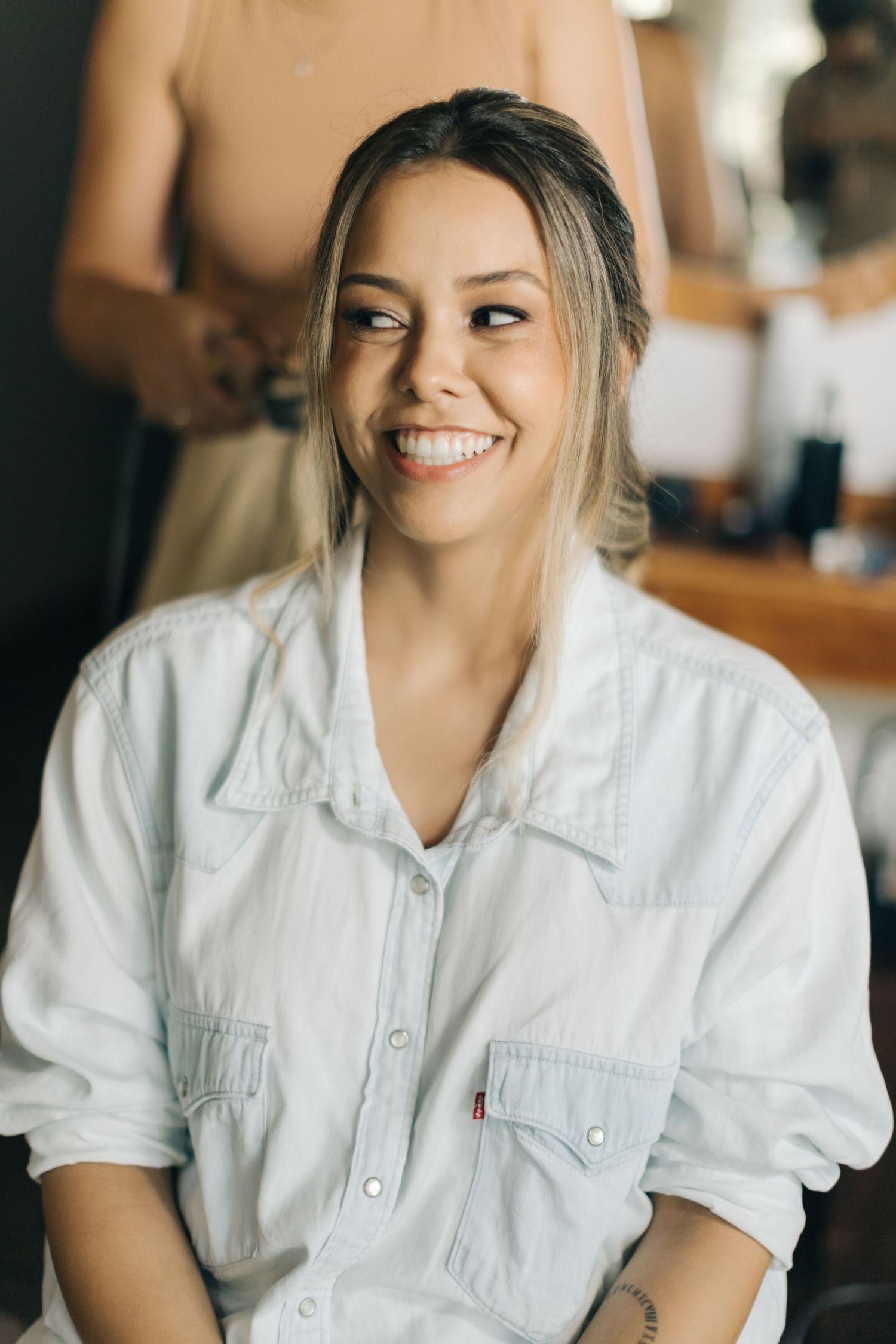 Person in white denim shirt smiling warmly during preparation session.