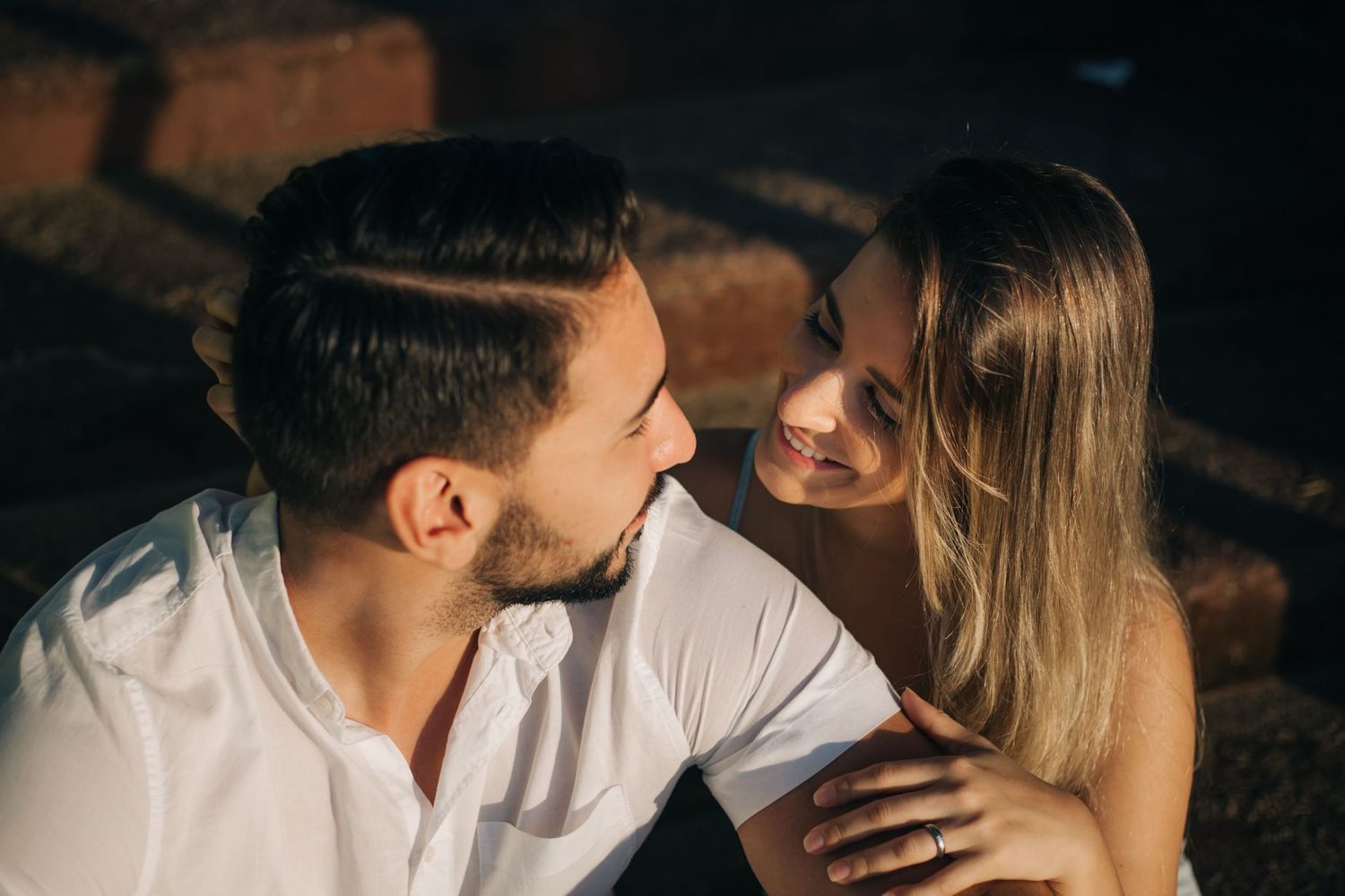 Close-up shot of couple's intimate interaction in moody lighting.