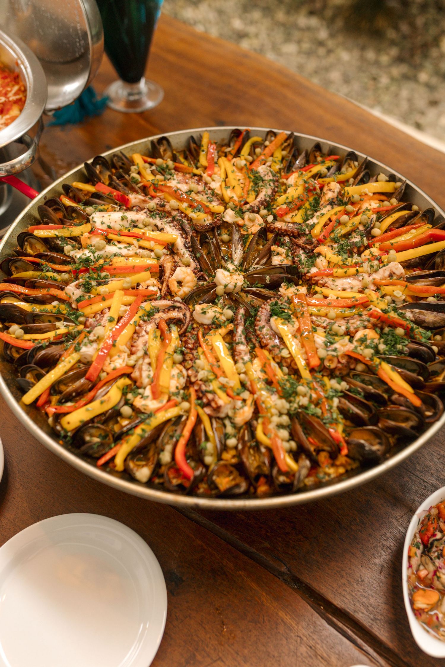 Beautifully arranged colorful vegetable dish in a large circular pan.
