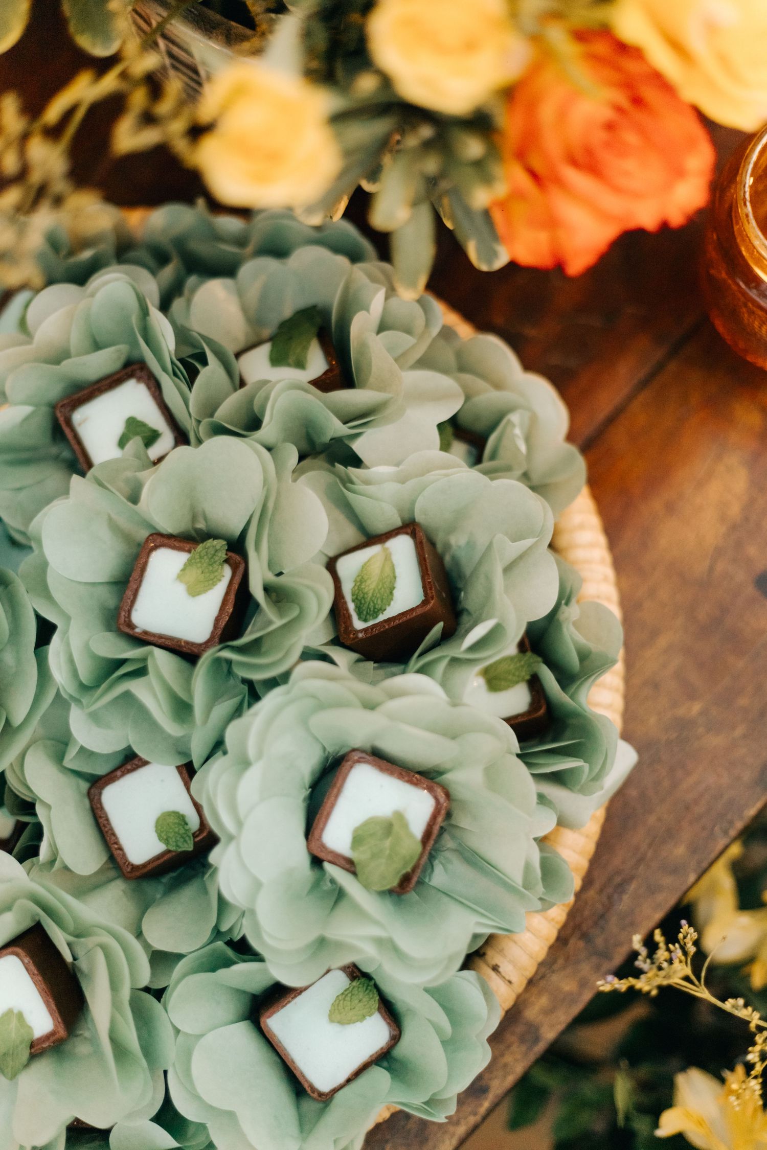 Delicate mint green paper flowers arranged in a decorative wedding dessert display.